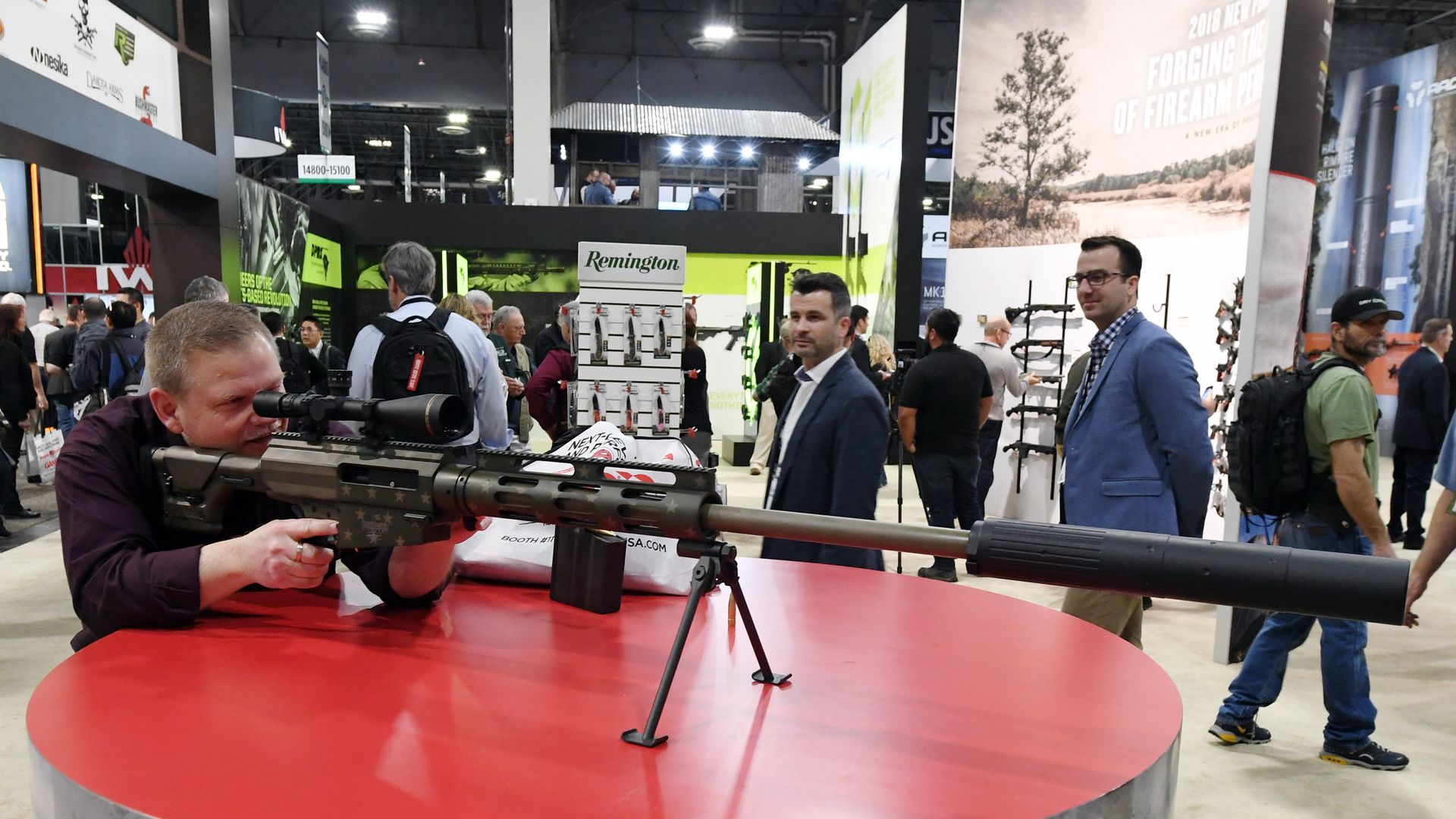 Man examines rifle at tradeshow.