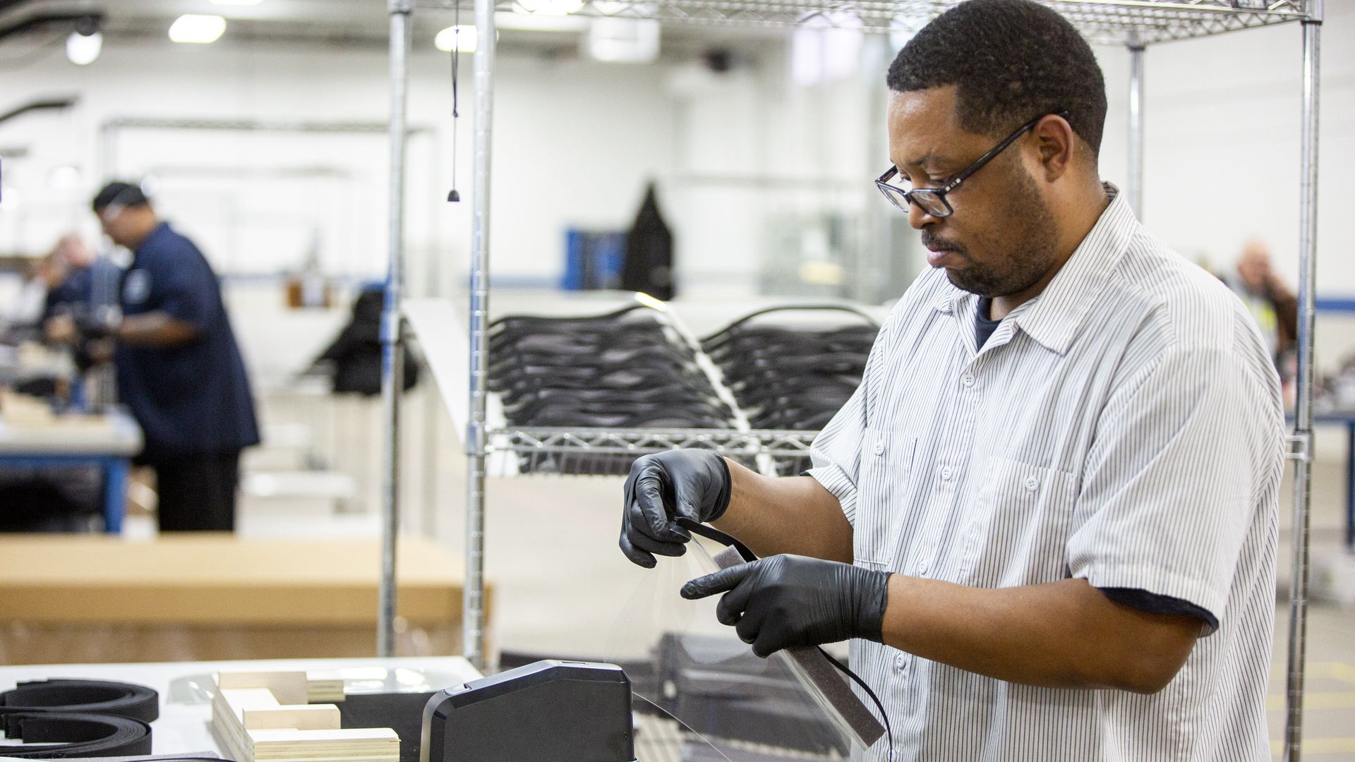 Ford worker assembles a transparent face shield