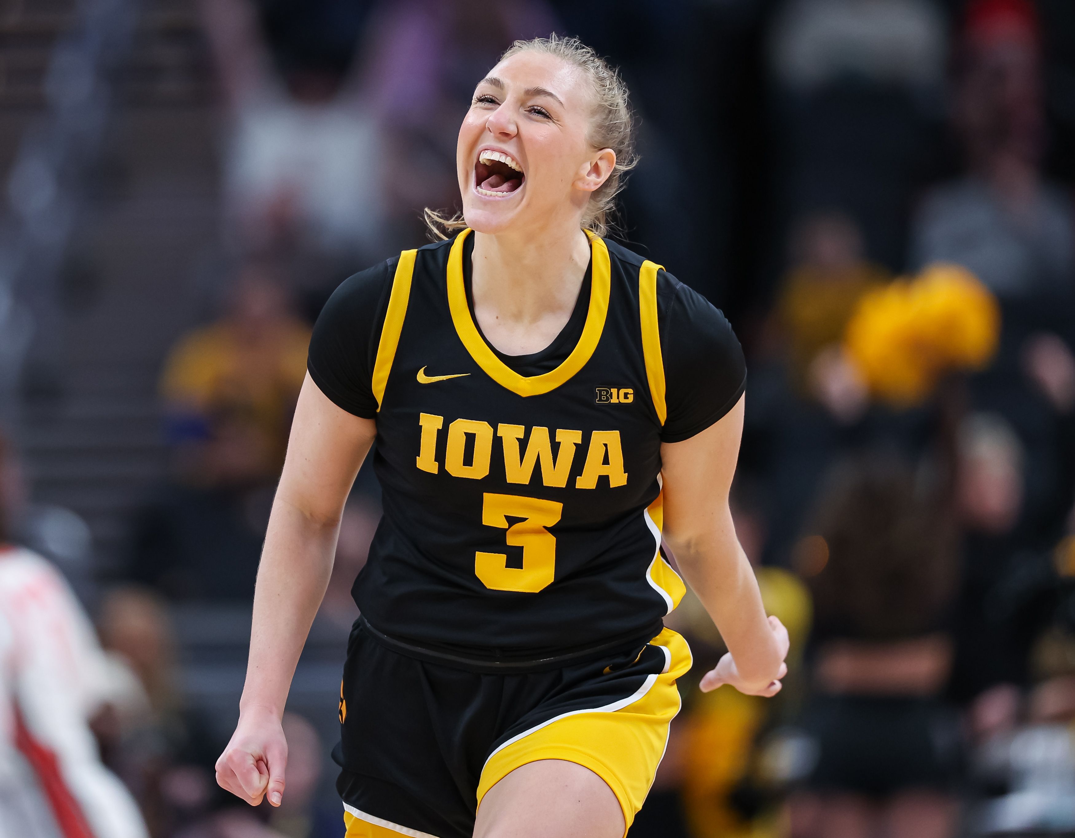 Photo of a woman in a basketball uniform celebrating during a game.