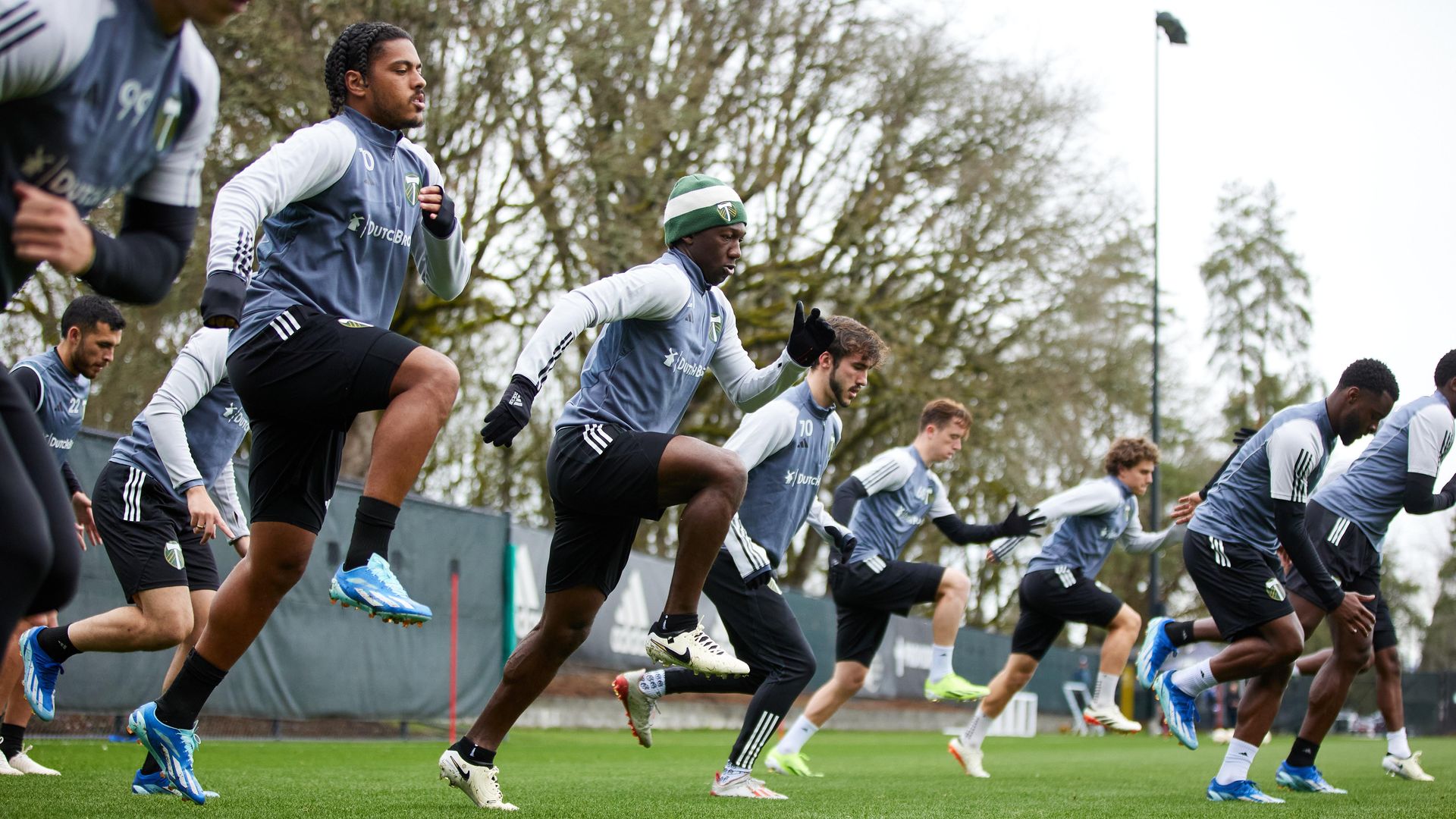 Soccer players running in training on grass.