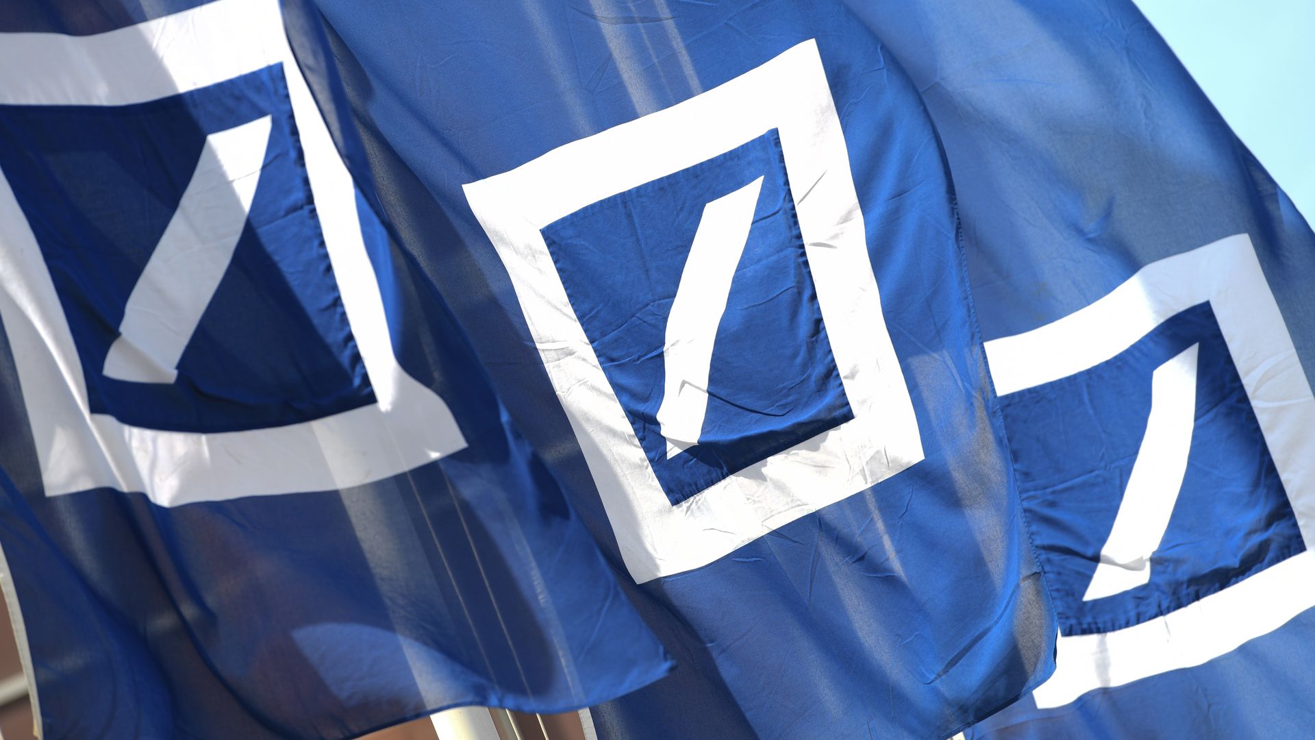 Deutsche Bank flags fly outside the bank's annual meeting.