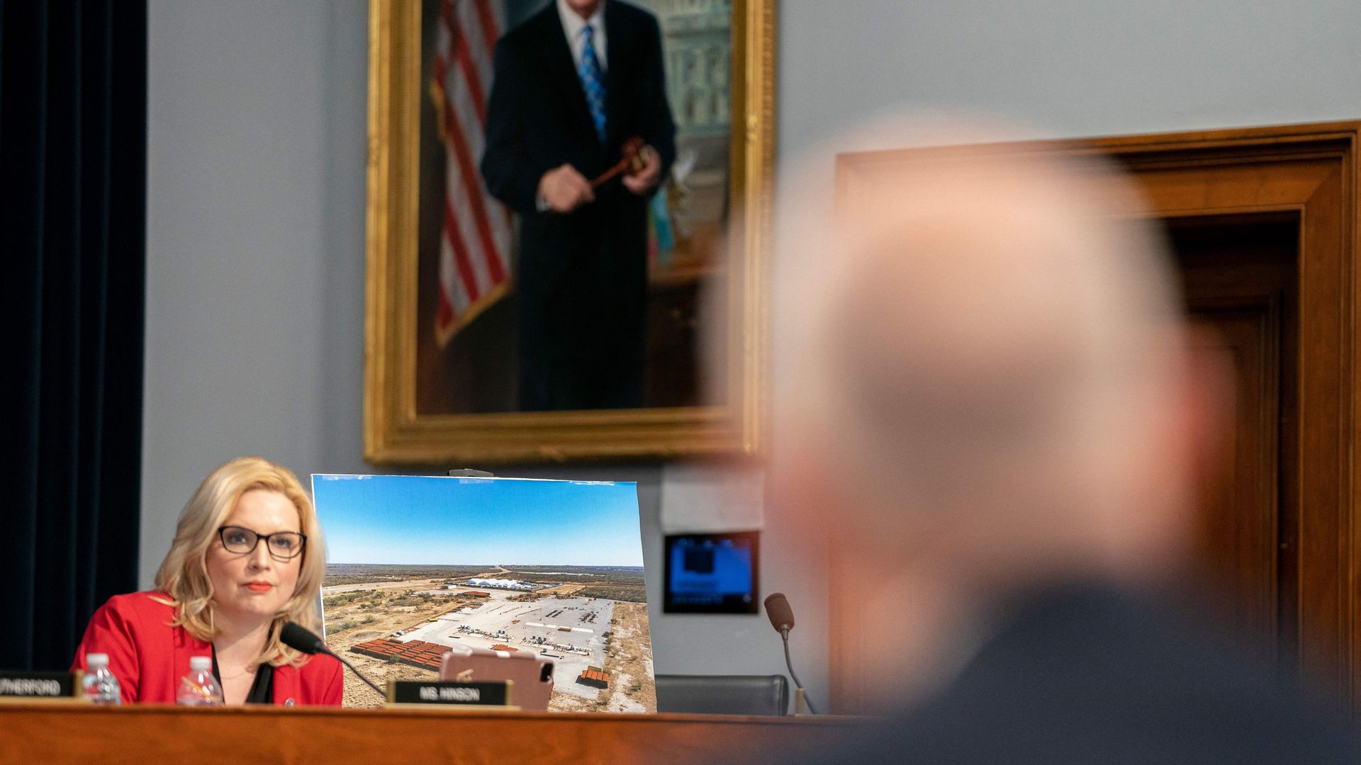 Homeland Security Secretary Alejandro Mayorkas is seen looking toward a photo of the U.S.-Mexico border.