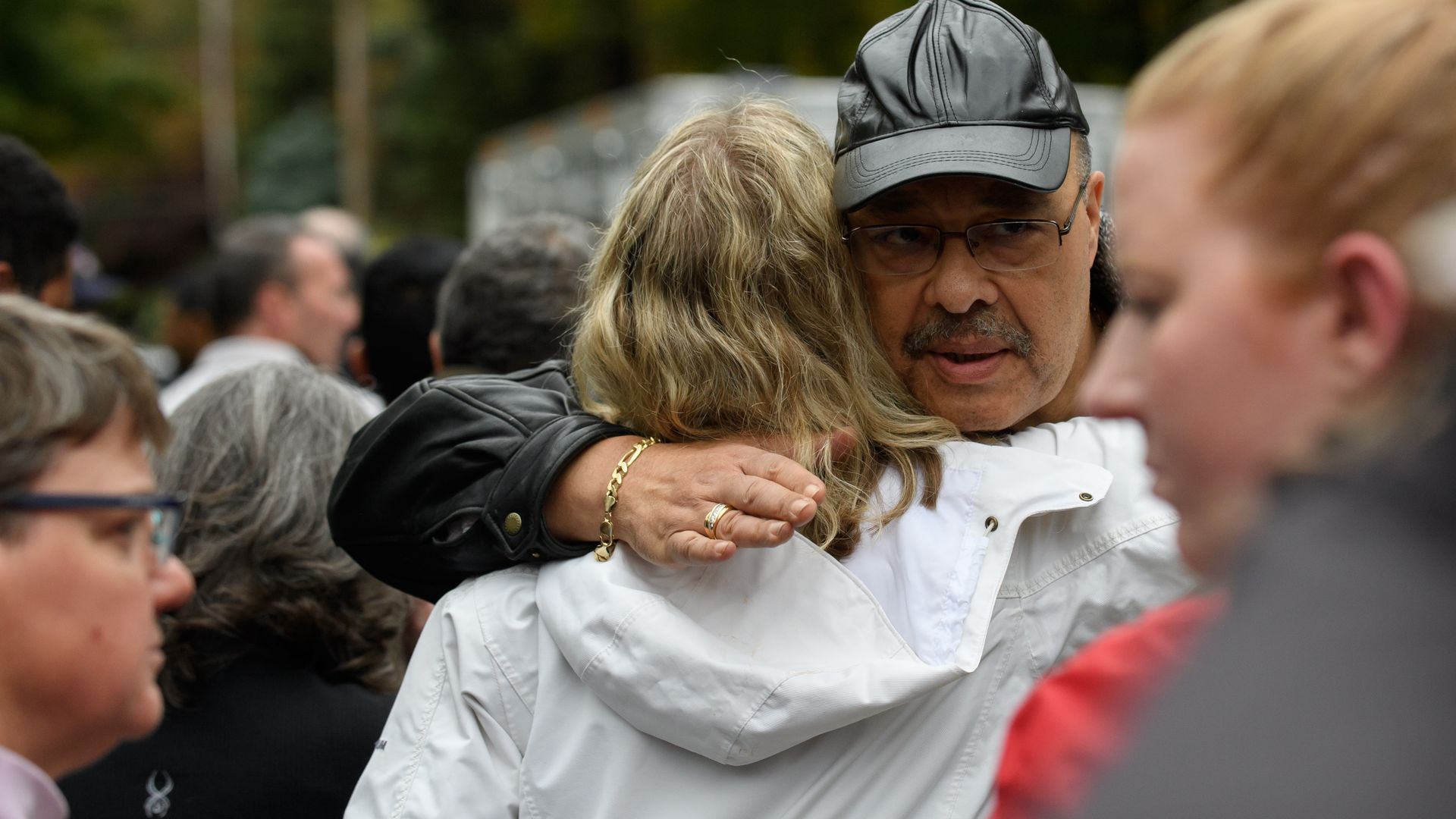 Man and woman hugging each other whlie at the crime scene of the pittsburgh shooting