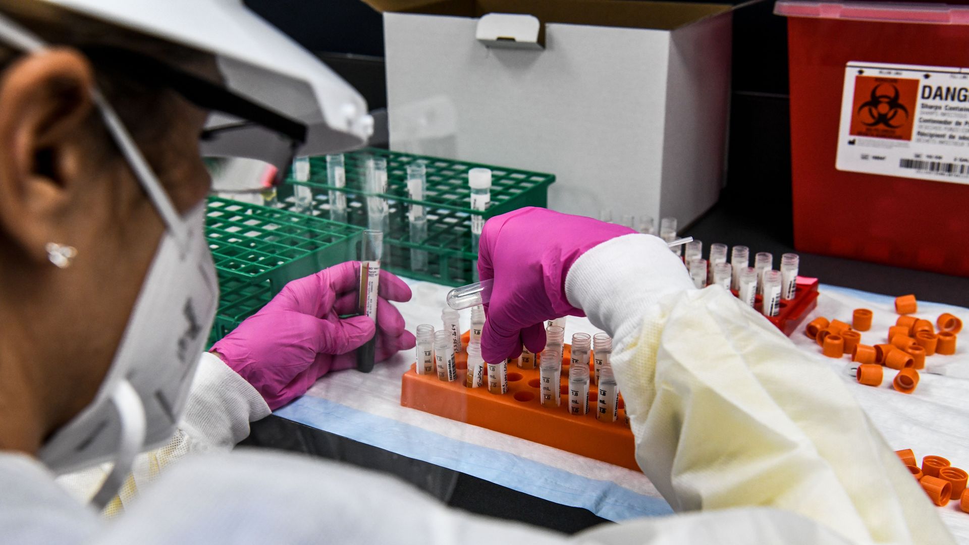A lab technician handling blood samples inside a lab for a coronavirus vaccine.