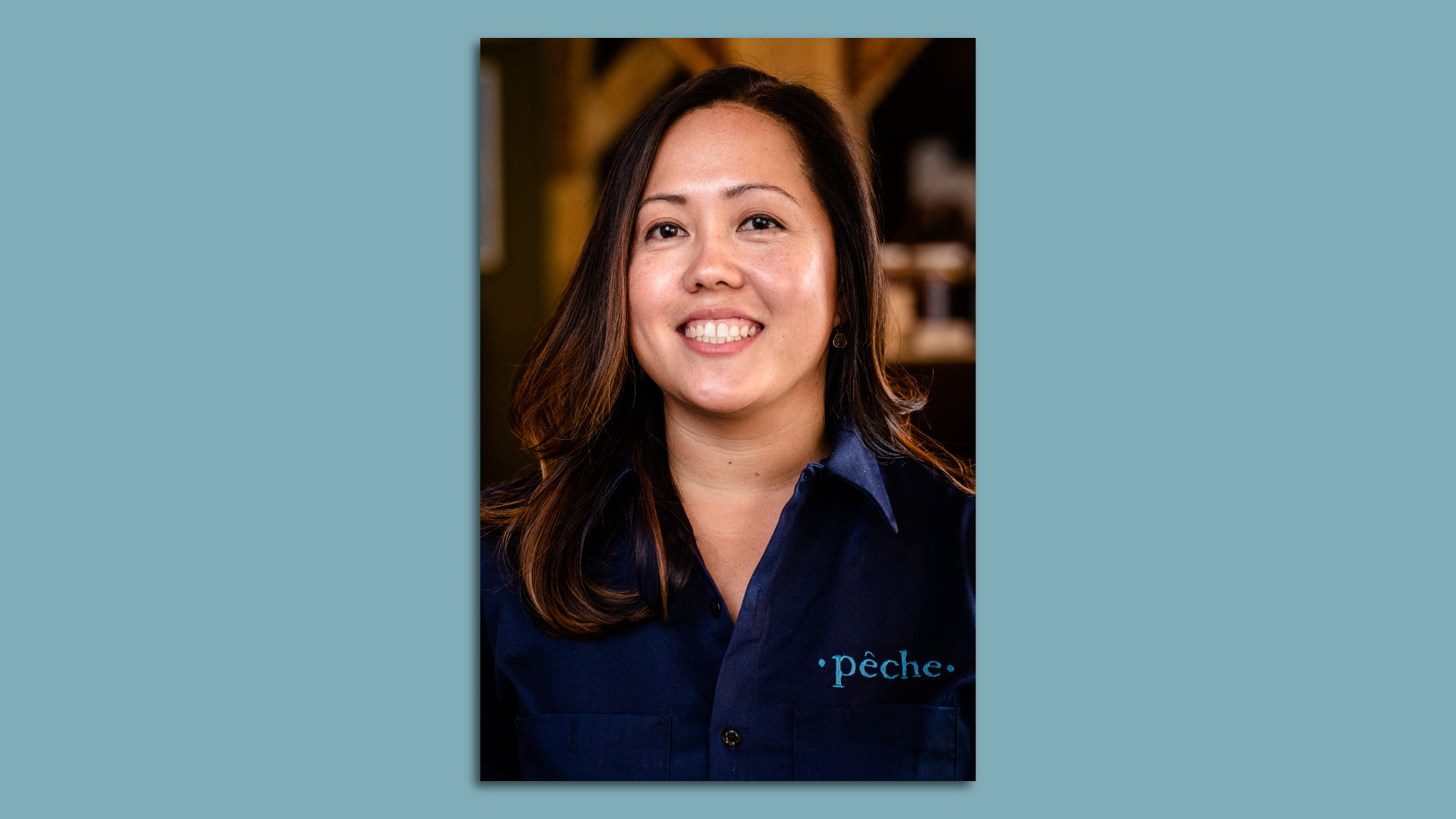 A woman smiles in a headshot photo. She wears a shirt that has the Peche logo on it.