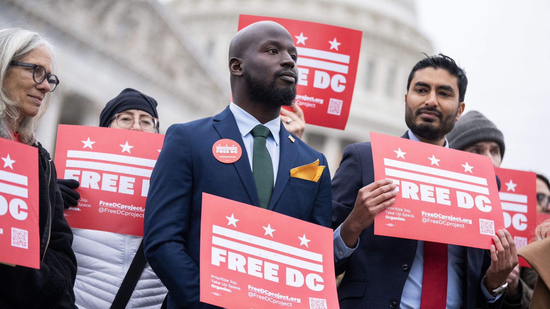 Oye Owolewa is at a press conference held outside the U.S. Capitol, where he's holding a "Free DC" sign