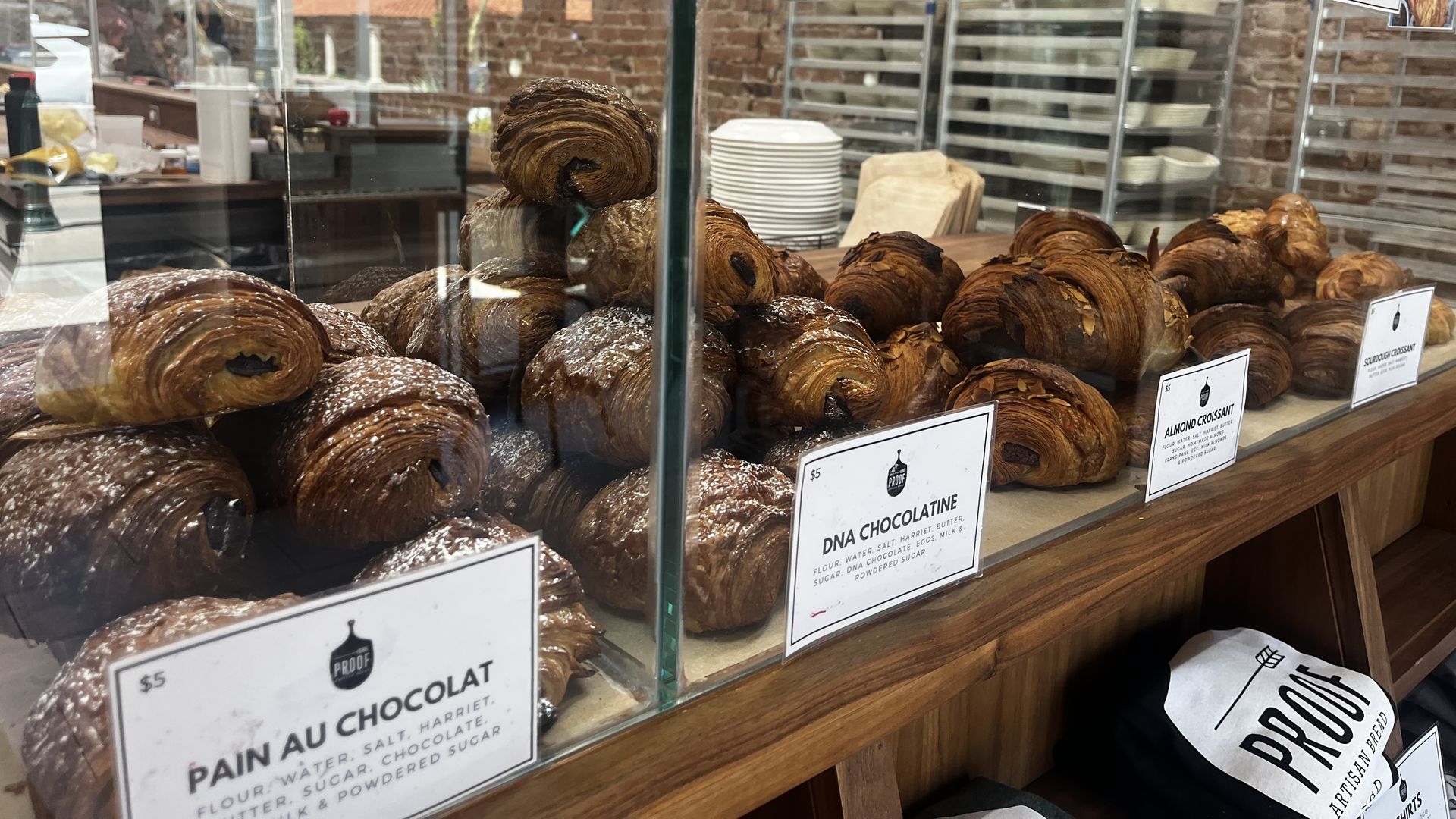 Dozens of croissants behind a glass screen. 