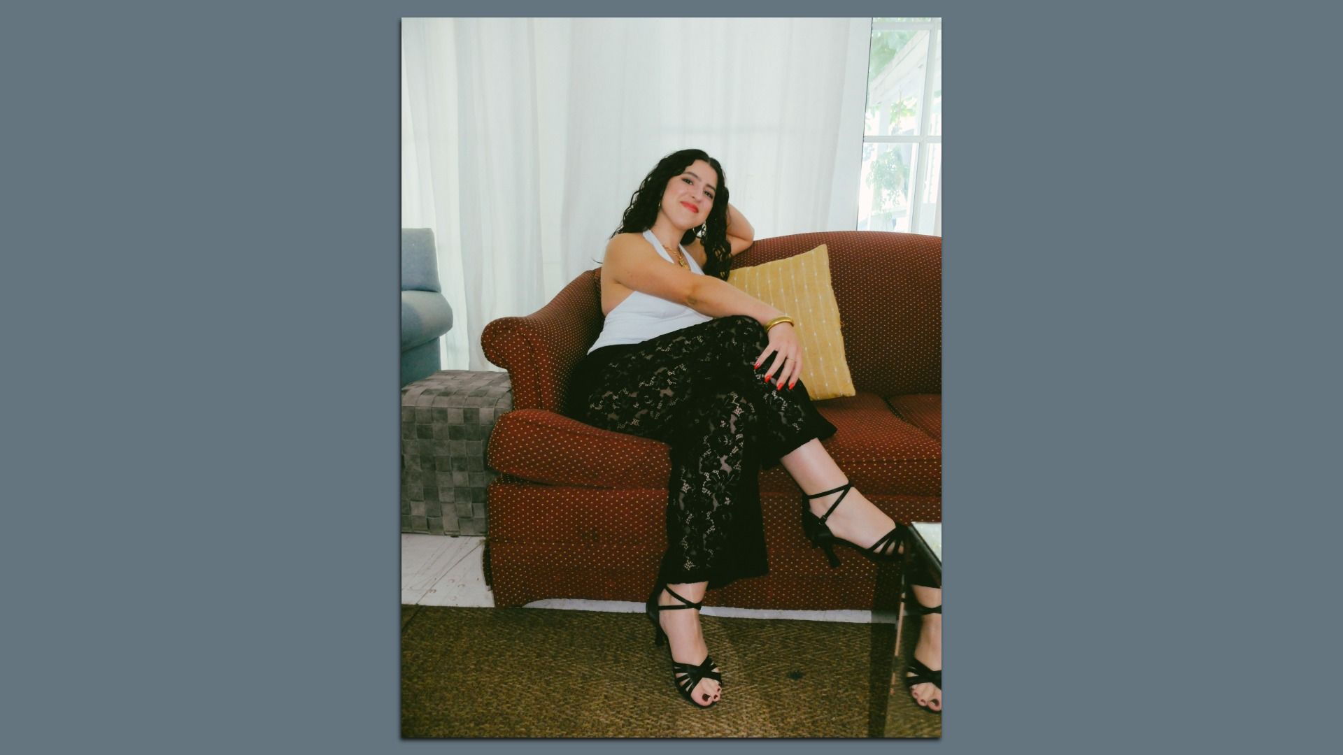 Elisa Baena smiling while sitting on a couch.