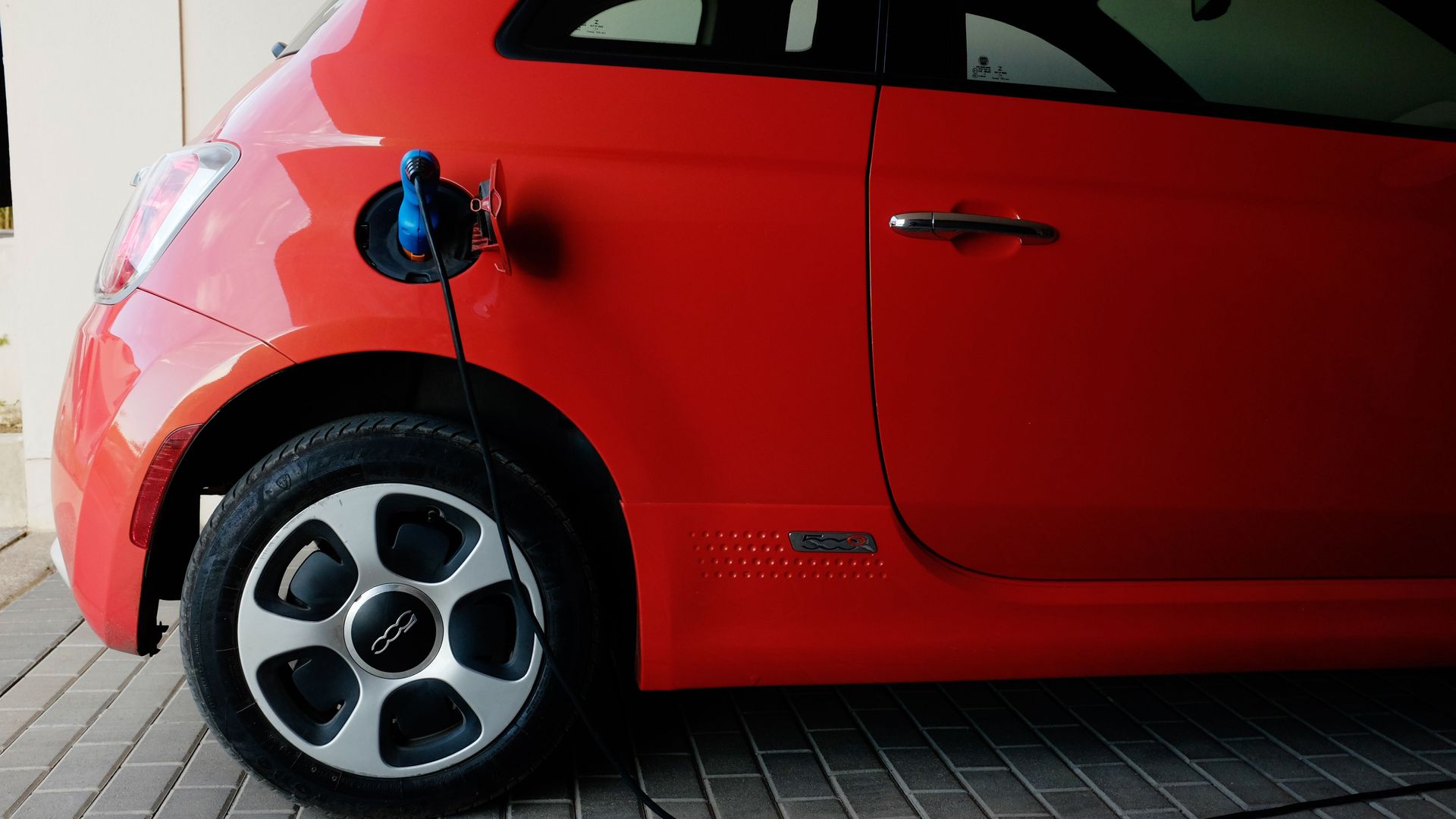 A red electric car gets charged in a lot in Costa Rica.