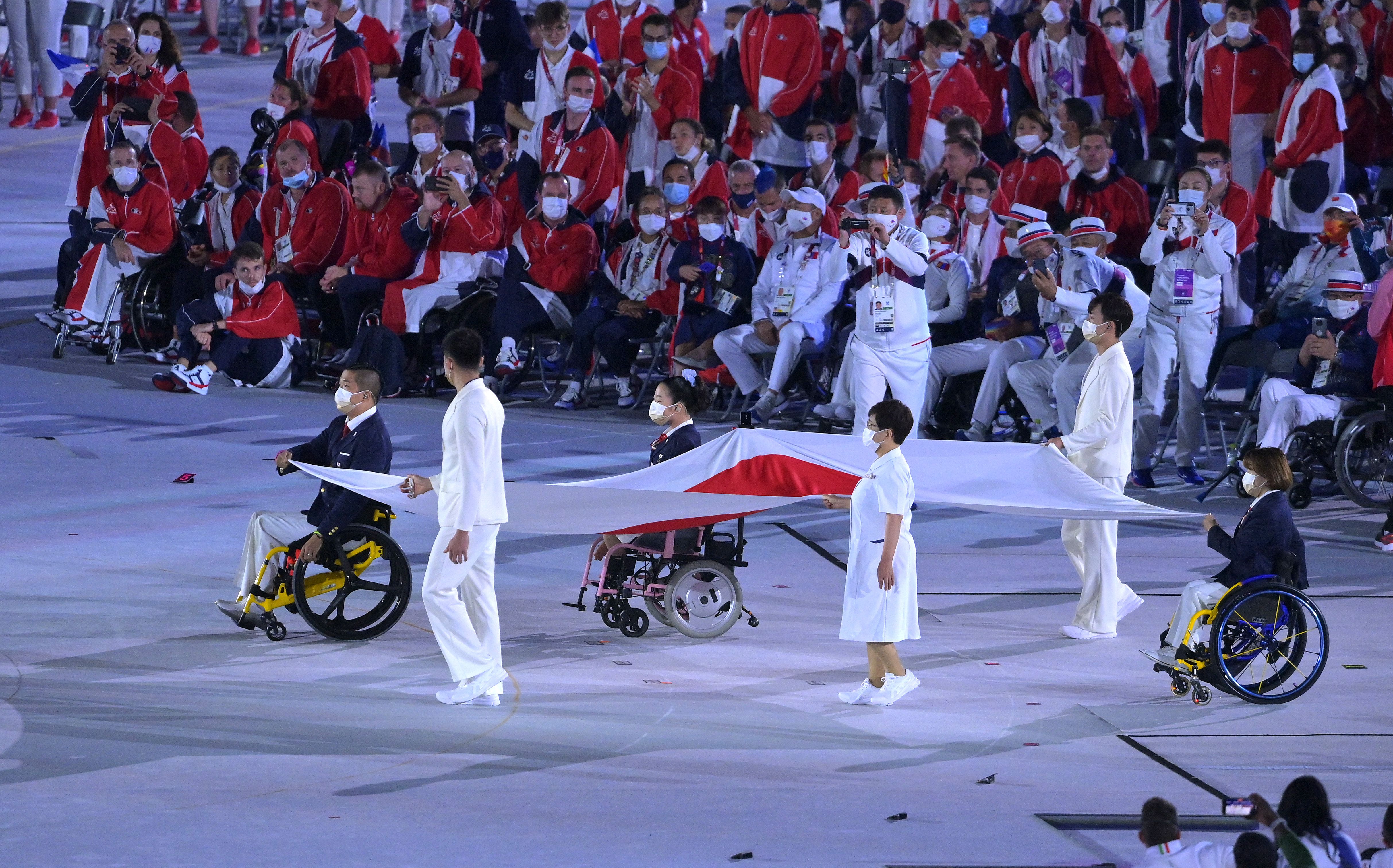 The national flag of Japan is carried into the stadium during the closing ceremony. 