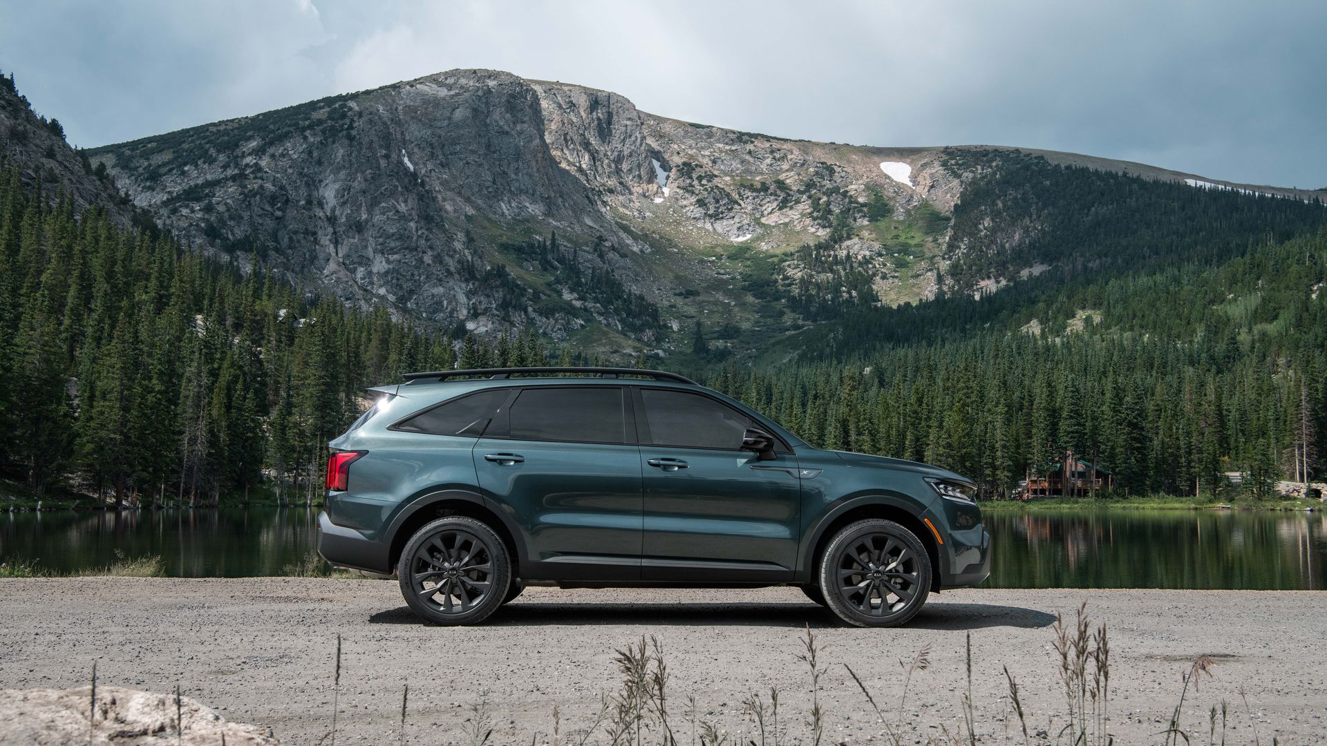 Photo of green 2021 Kia Sorenta X-Line SUV in front of beautiful mountains.