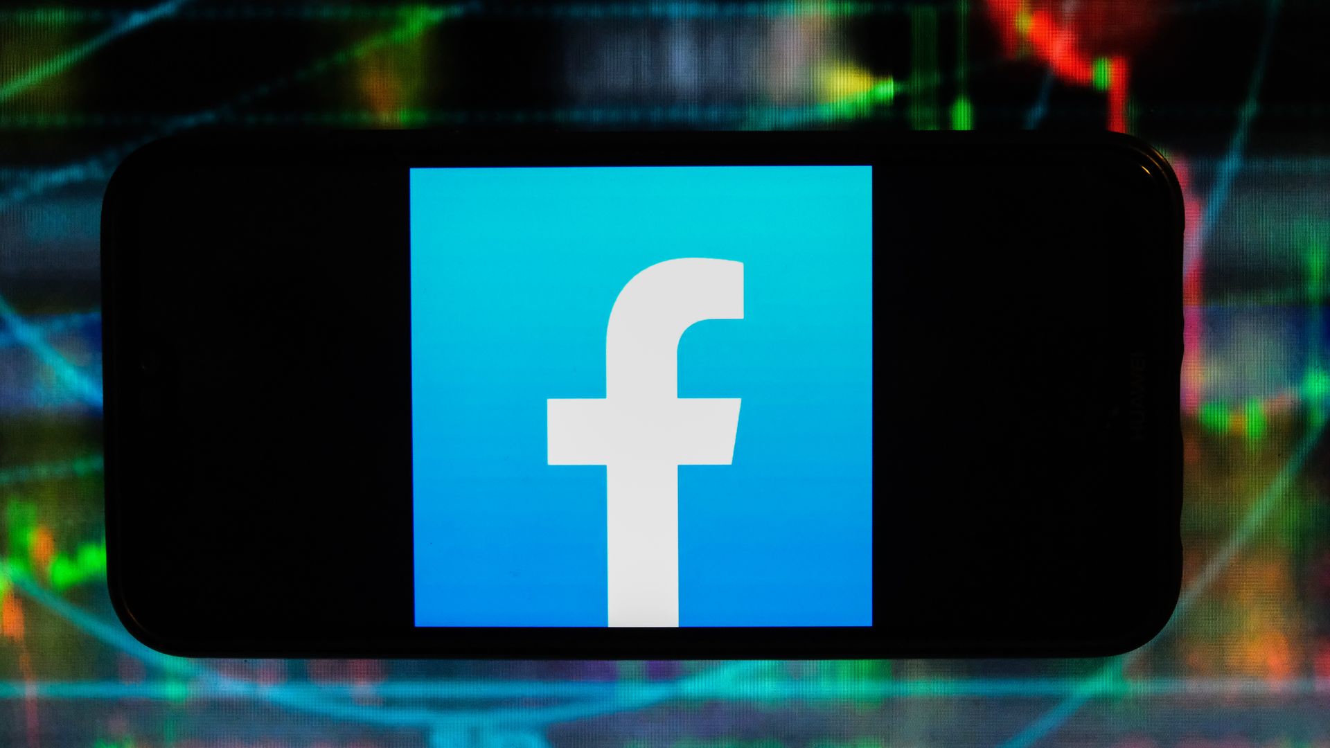 A photo of a smartphone displaying the Facebook logo