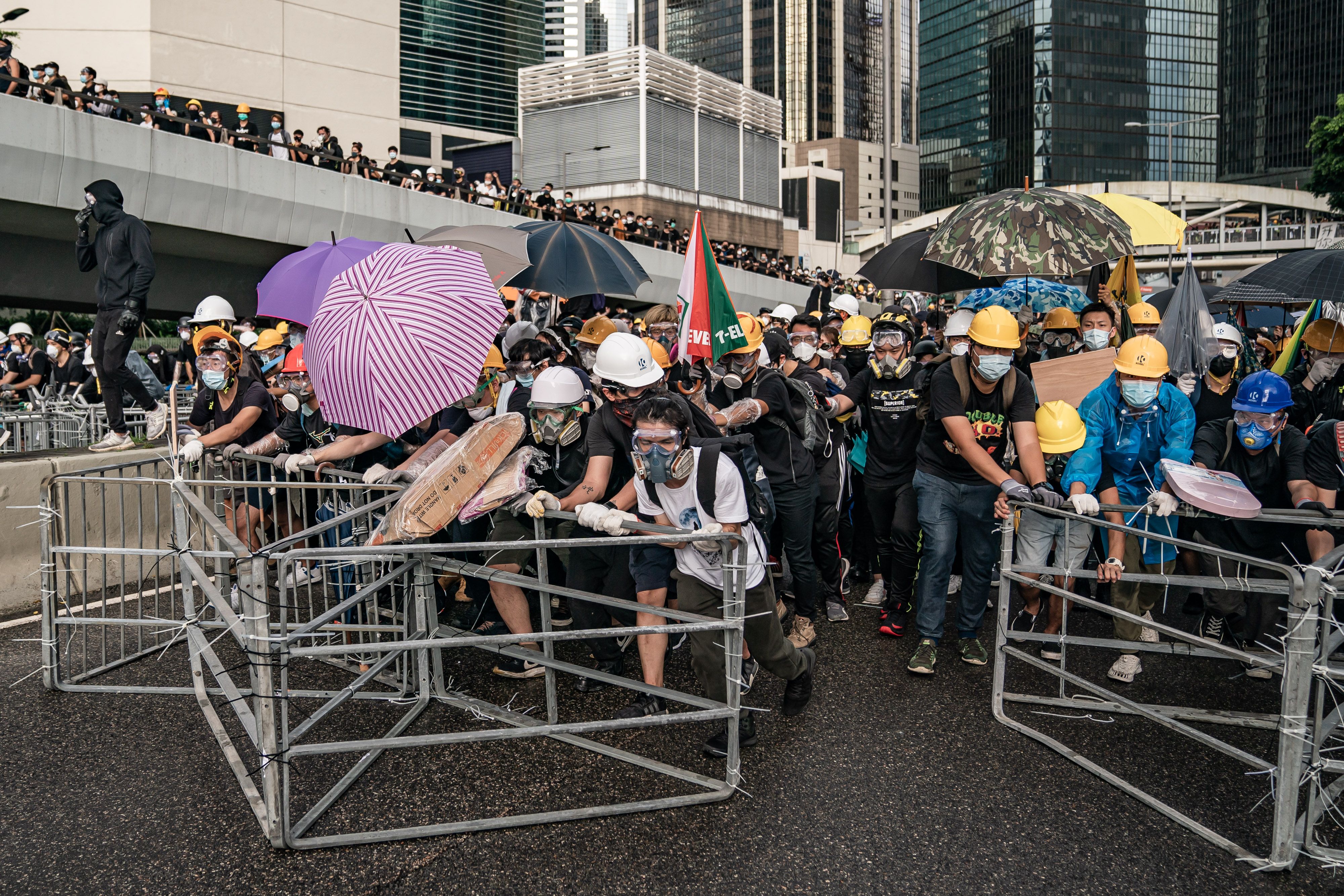 Anti-extradition protesters push barricades toward police on a street during a stand-off outside the Legislative Council Complex.