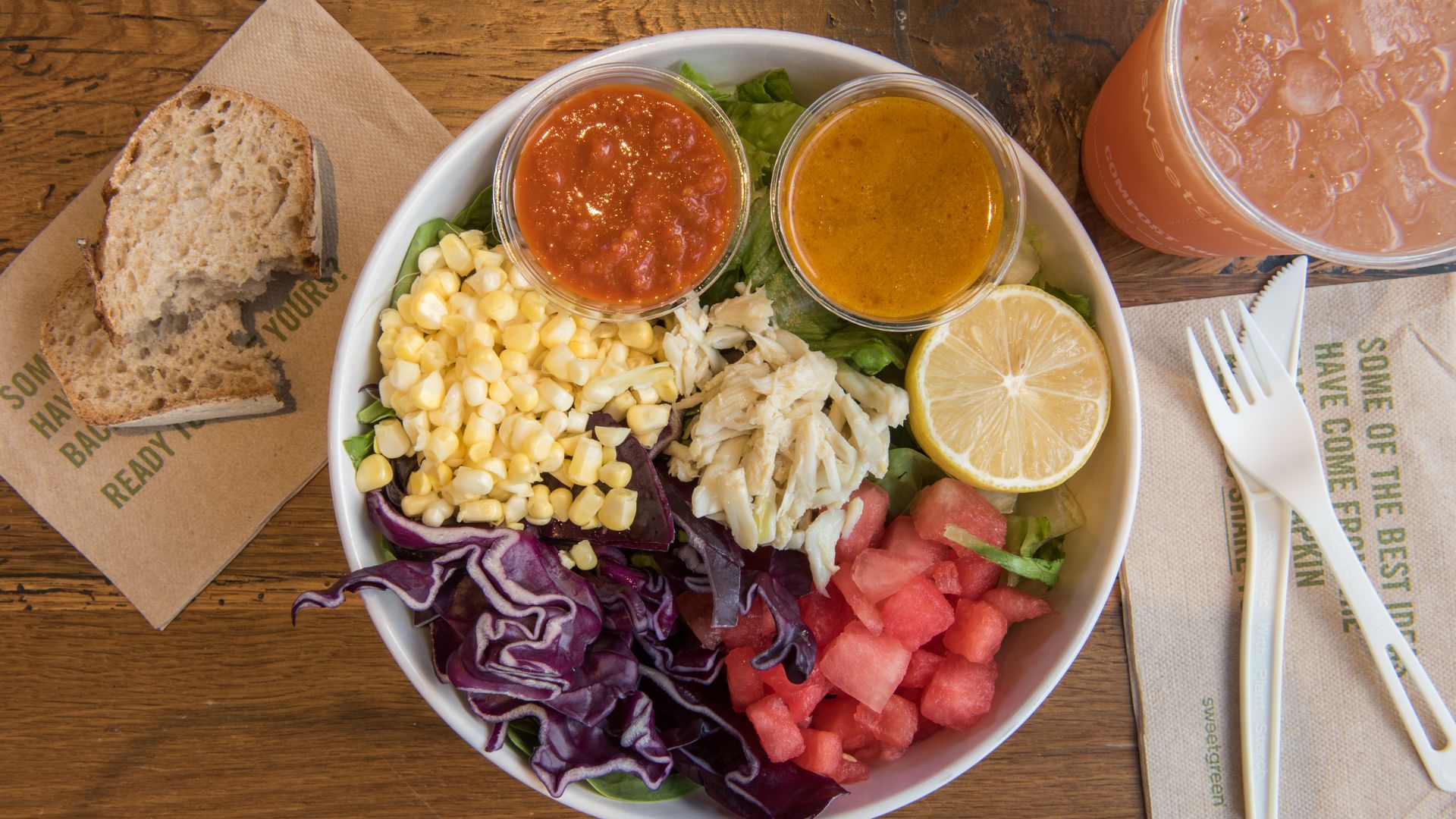 A bowl of salad with corn, cabbage, crab and watermelon on top 