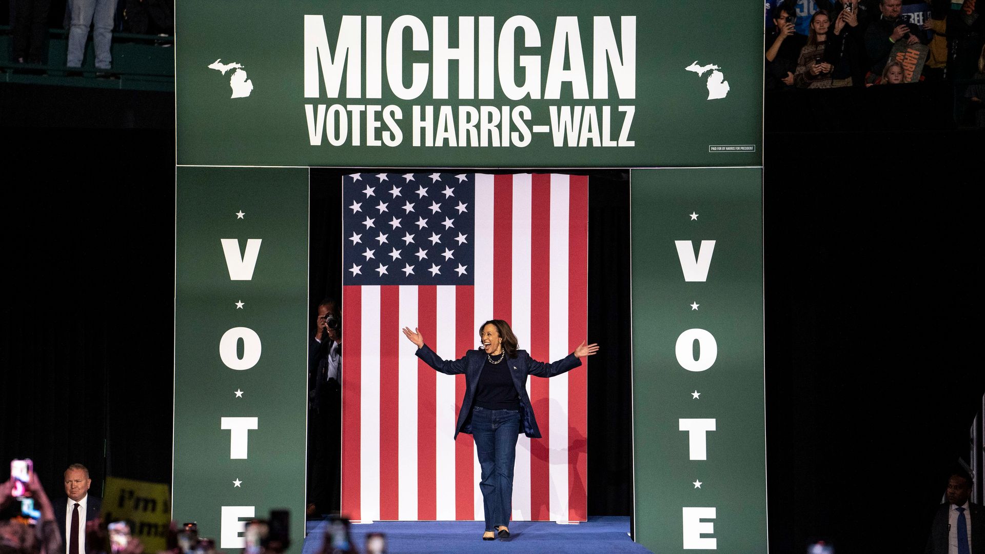 Harris in front of a green background and a U.S. flag