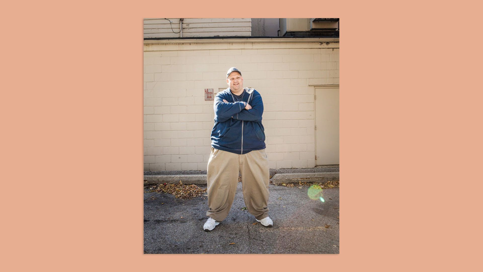 An image of former Des Moines Register metro columnist Dan Finney standing outside an unknown building with his arms crossed.