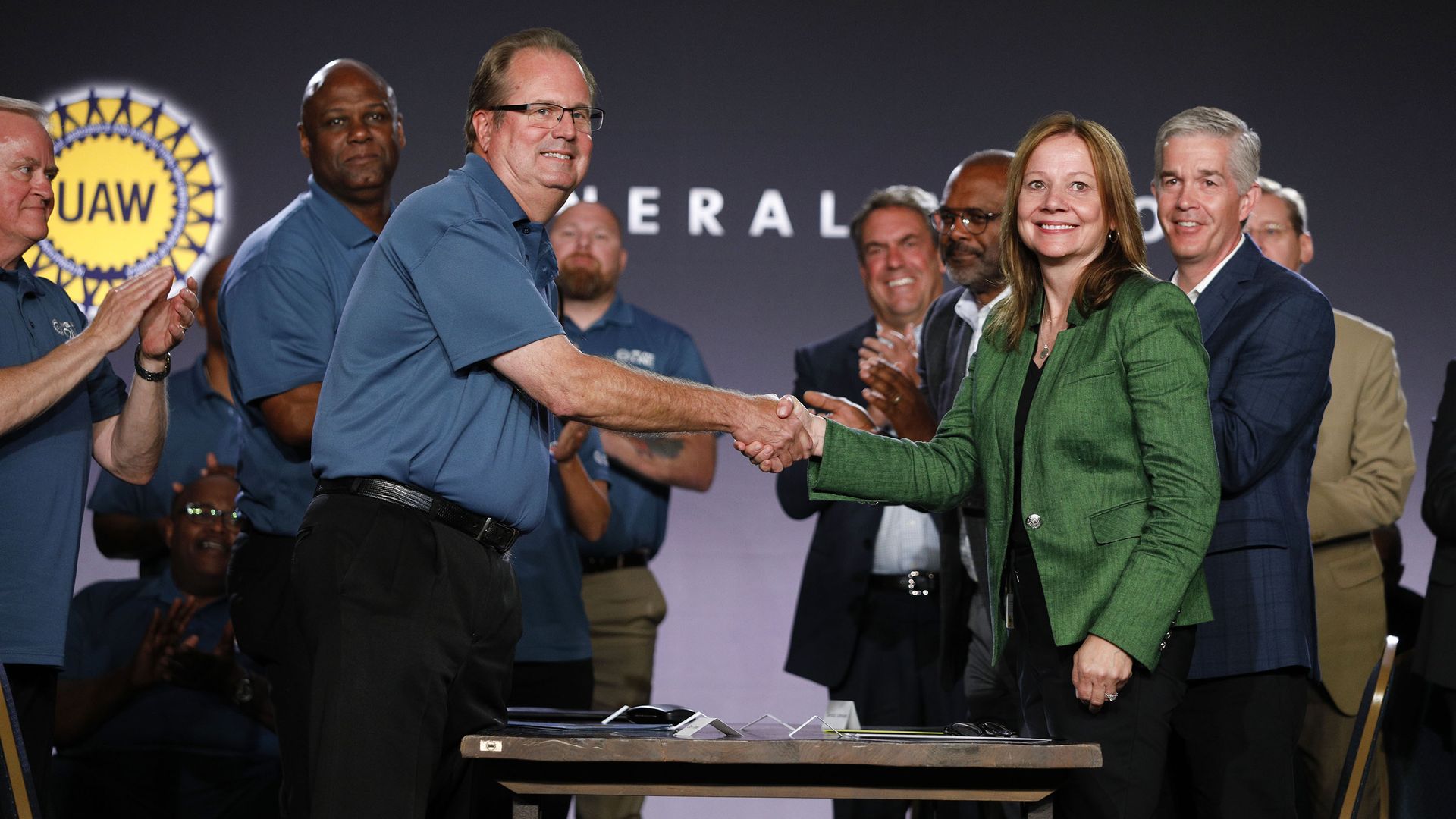 Image of ceremonial handshake between GM CEO and UAW President to launch contract talks