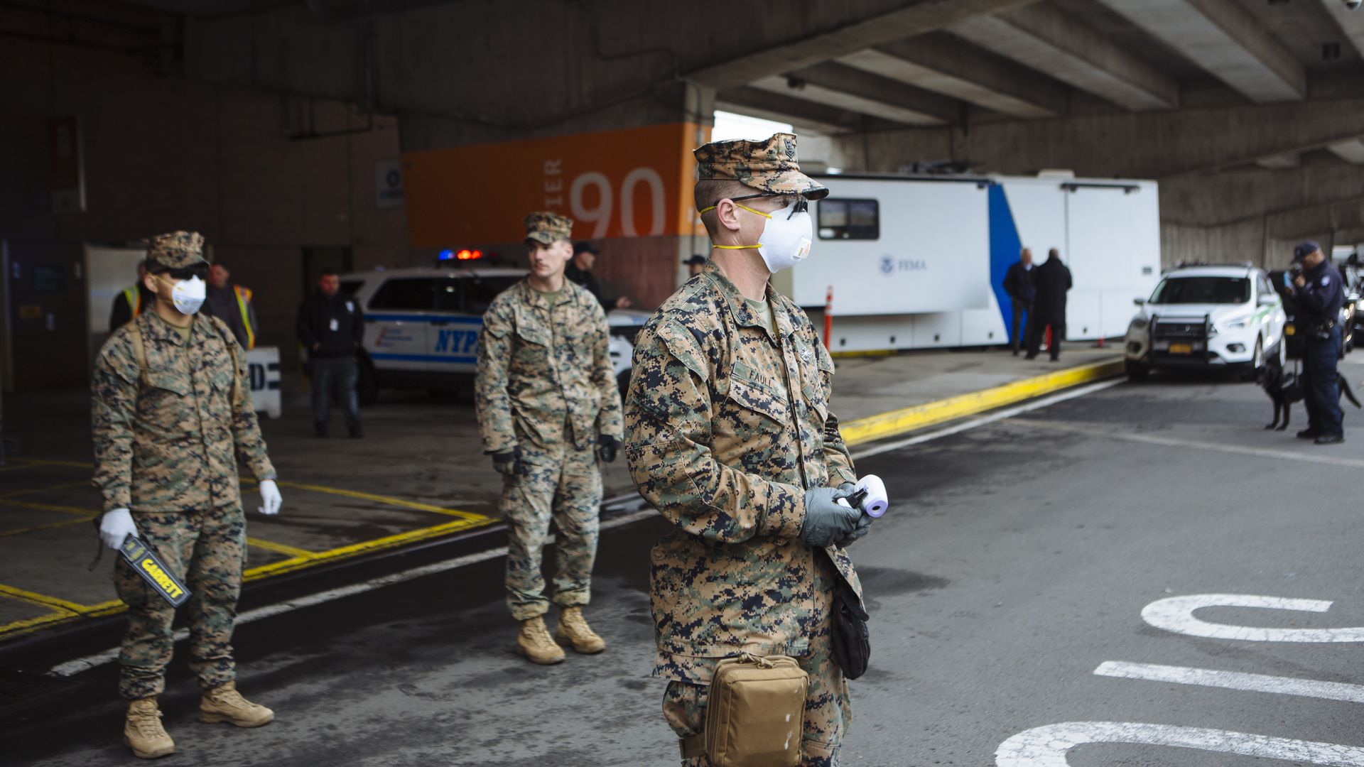 Members of the U.S. Marines wearing protective equipment stand guard as the USNS Comfort hospital ship arrives at Pier 90 in New York, U.S., on Monday, March 30, 2020