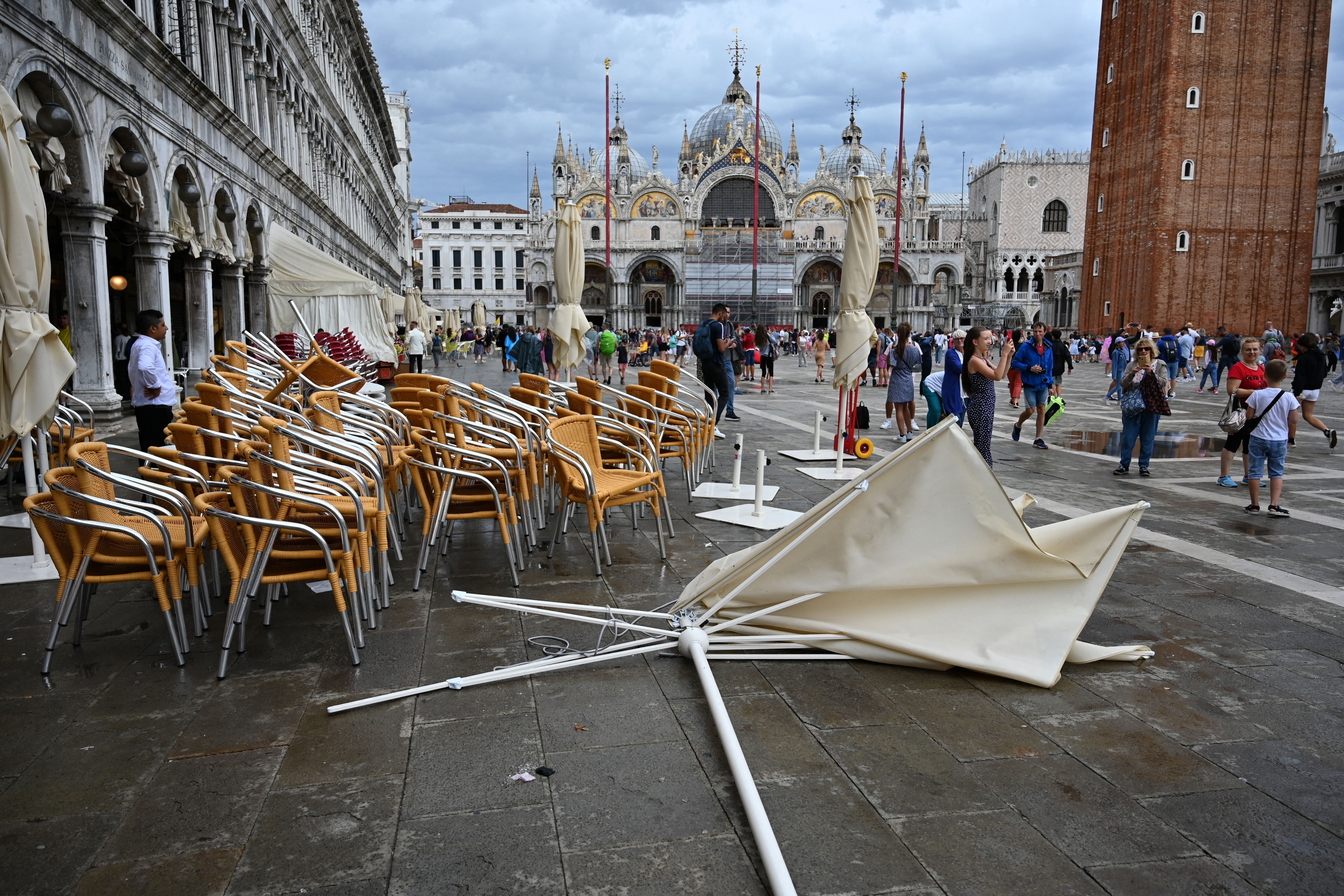 A parasol lies on the ground on the terrace of the Eden bar at Piazza San Marco in Venice on August 18, 2022, as a result of bad weather.  