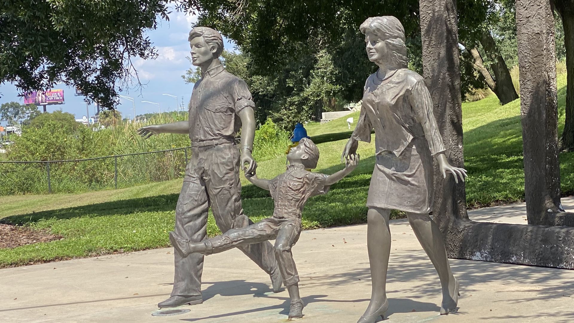 A statue of a father, mother and child walking.