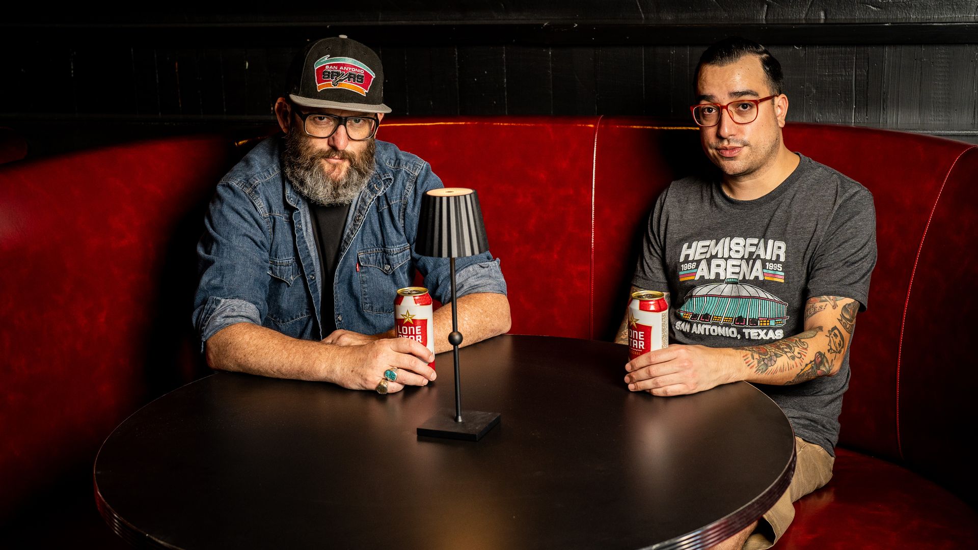 Roger Herr and Aaron Pena side-by-side in a red booth.