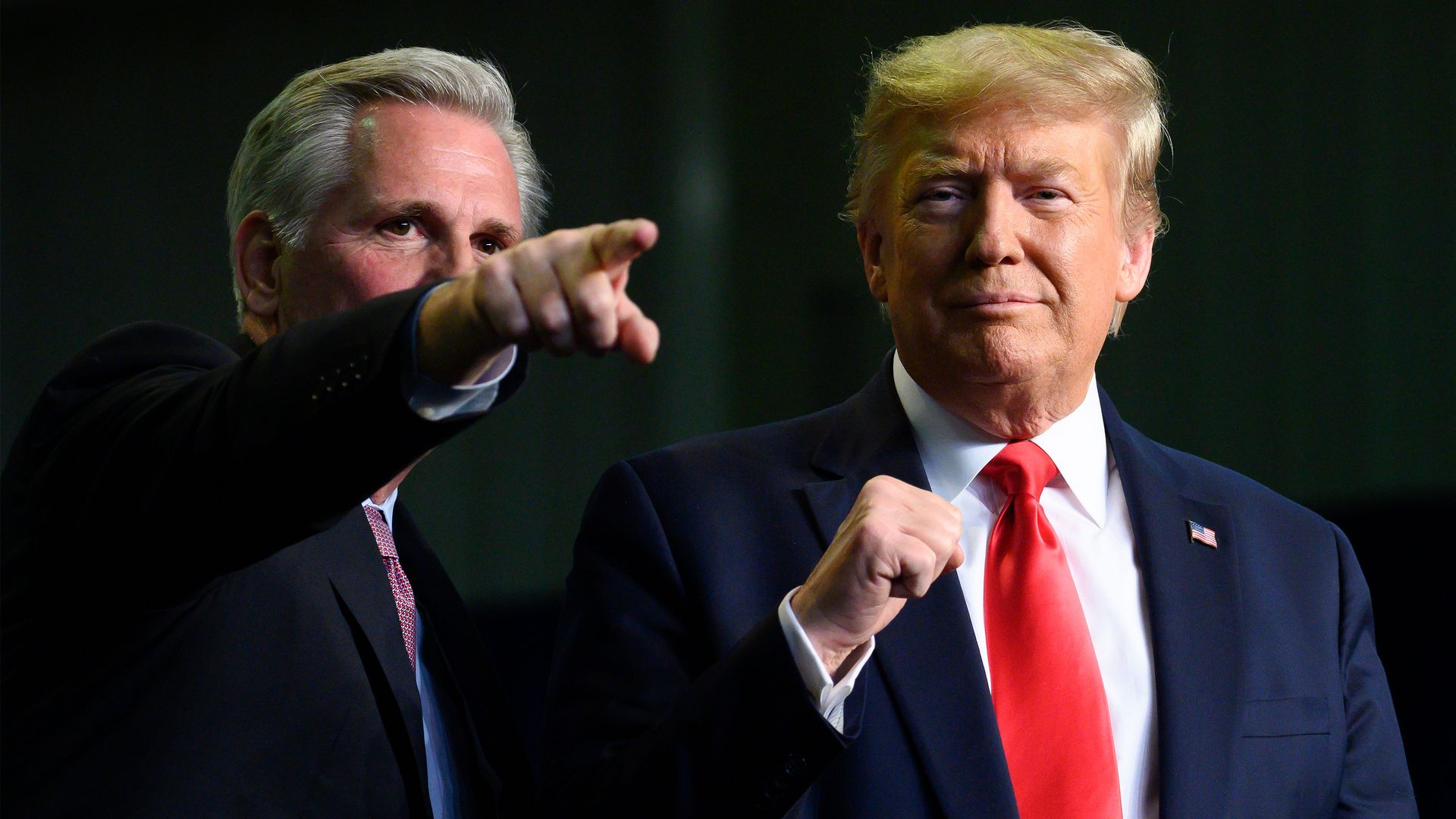 House Republican leader Kevin McCarthy points and then-President Donald Trump pump his fist at an event together in 2020