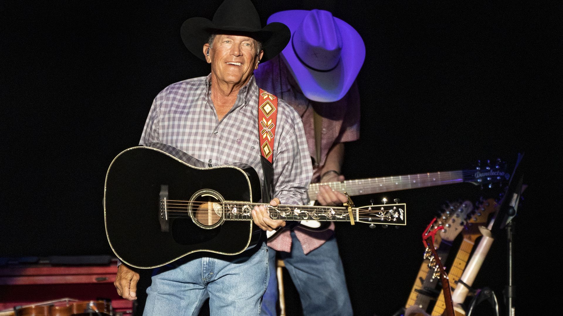 George Strait performs the guitar at a live concert. 