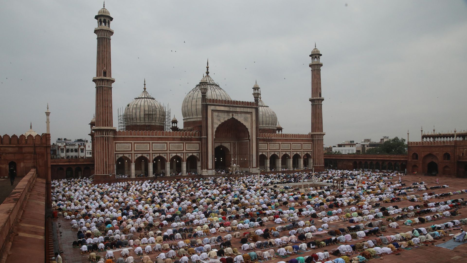 Rows of people kneel in prayer 