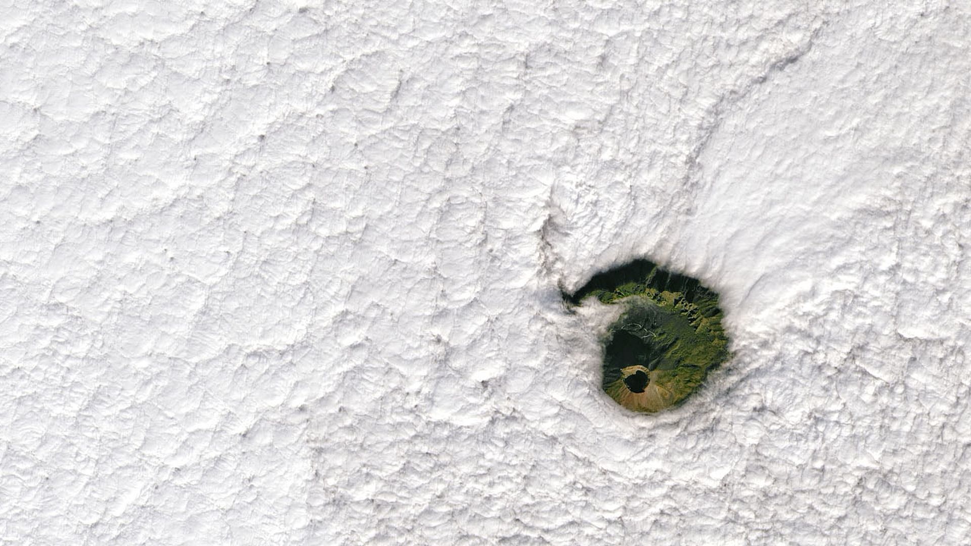 Mount Vesuvius seen poking through the clouds by a satellite