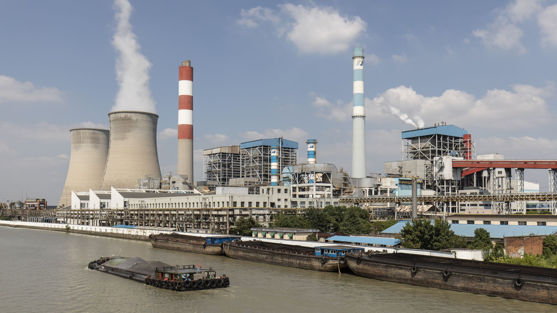 A barge travels past the Wangting Power Plant in Wangting, China, on Sept. 30.