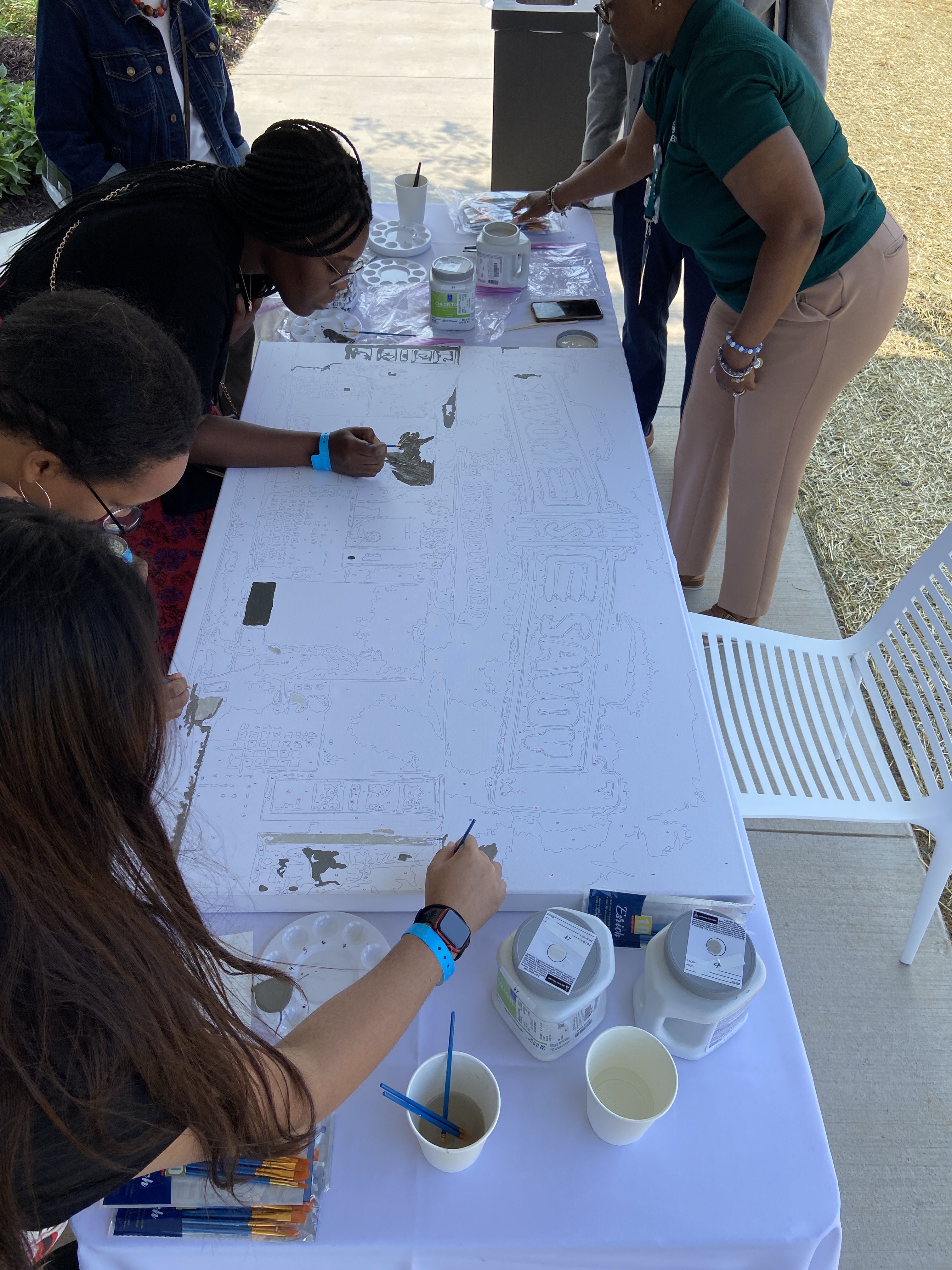 People fill in a paint-by-numbers of the Savoy Theatre.