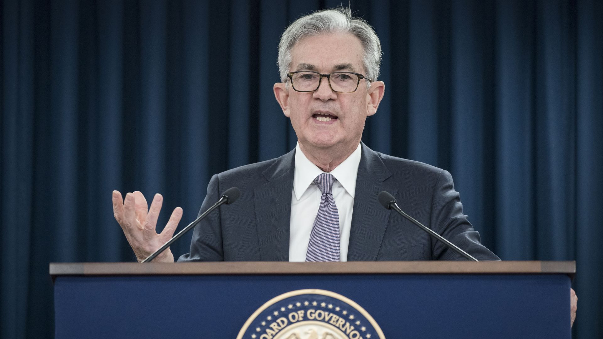 Federal Reserve chairman Jerome Powell stands at a podium at a press conference 