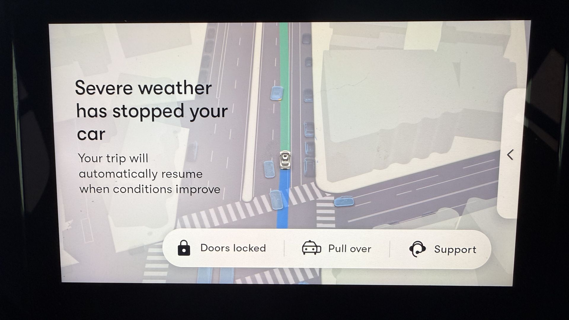 A screen in a Waymo car displaying a message that "Severe weather has stopped your car"