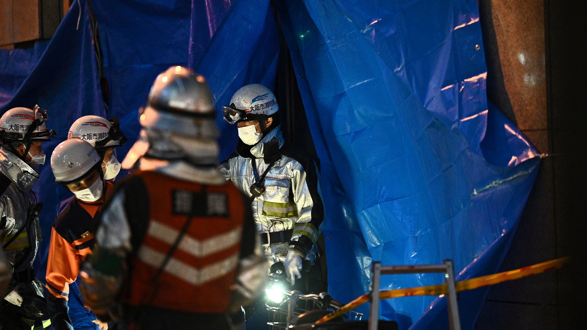 Firefighters working outside of an office building in Osaka, Japan, where a fire broke out on Dec. 17.