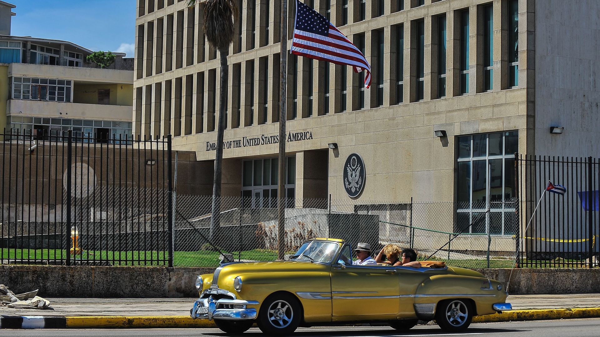 A classic car drives past the U.S. Embassy in Havana
