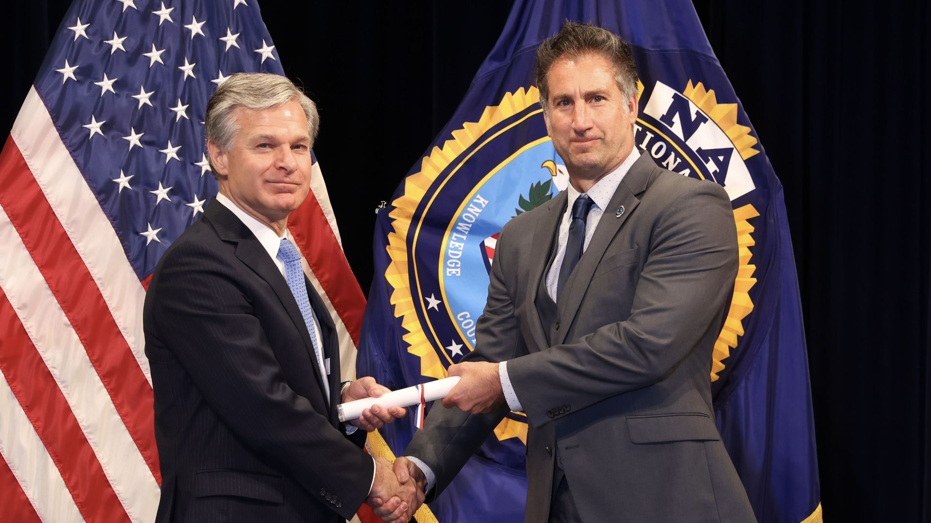 Two men shake hands.