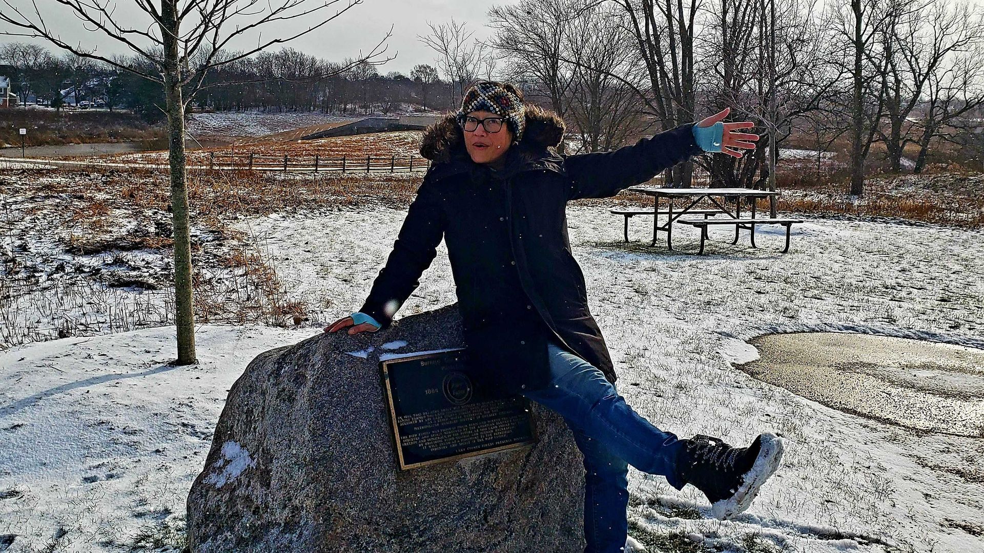Photo of a woman posing on a rock. 