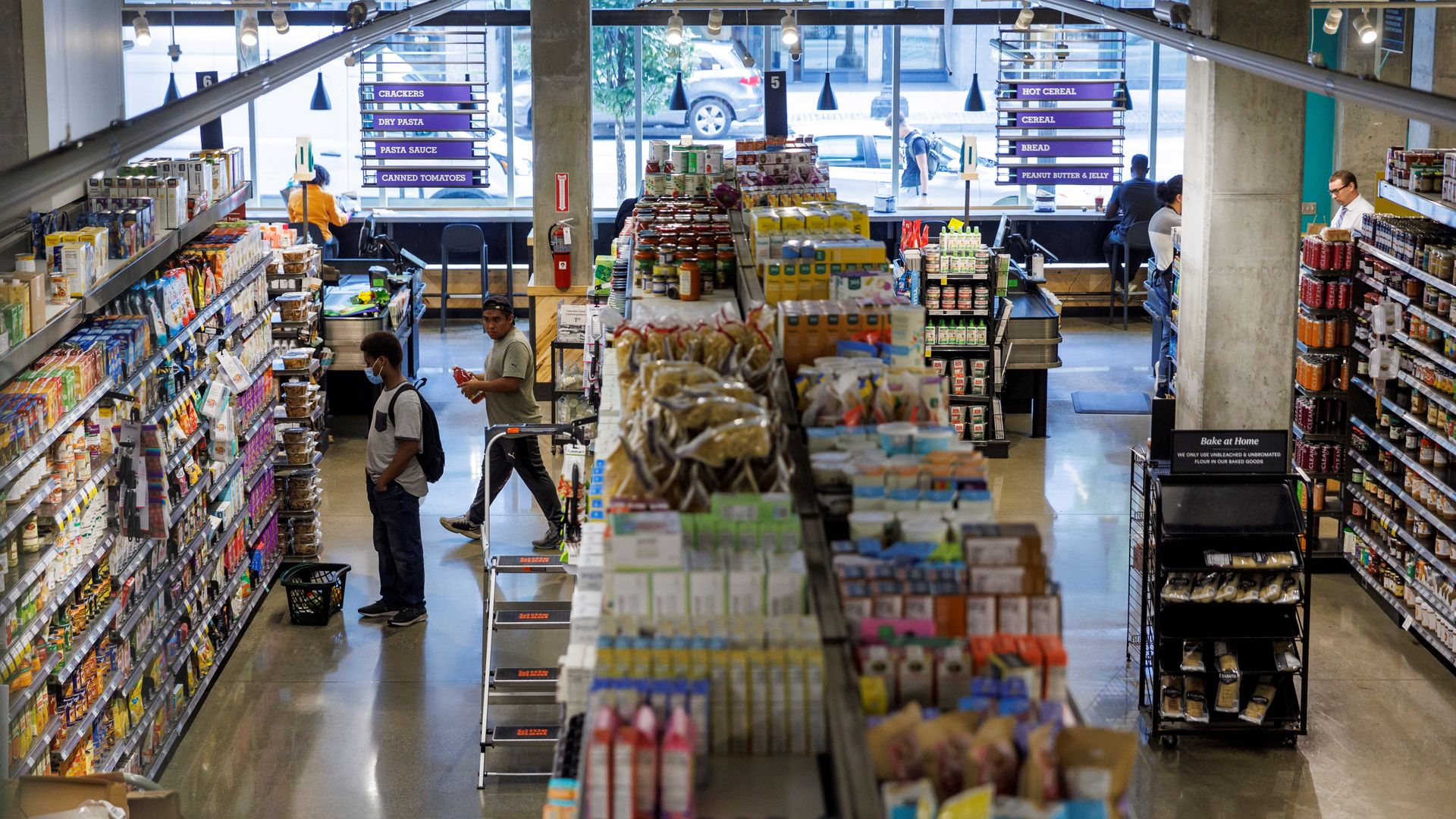 Photo of a bird's eye view of a grocery store with people standing in the aisles