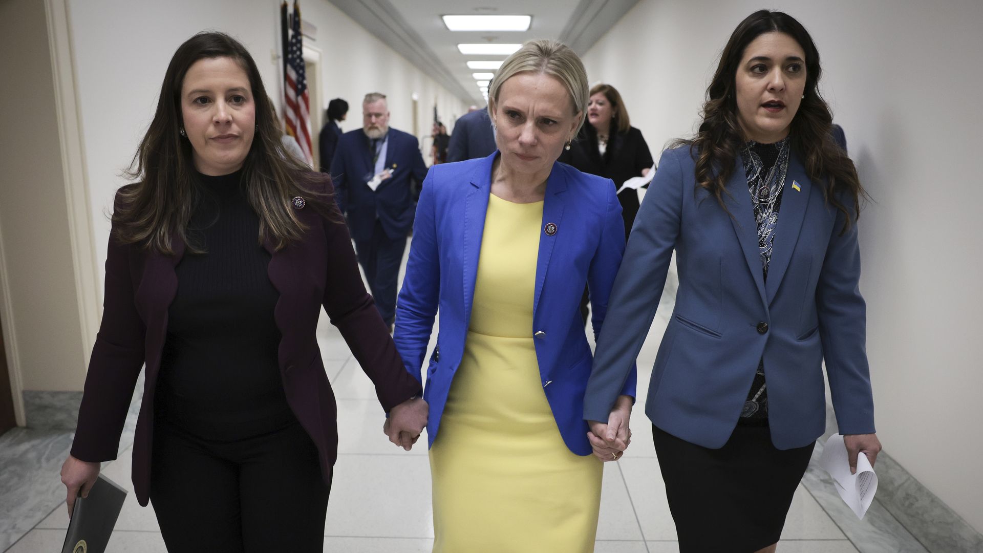 Members of Congress are seen holding hands with a colleague born in Ukraine.