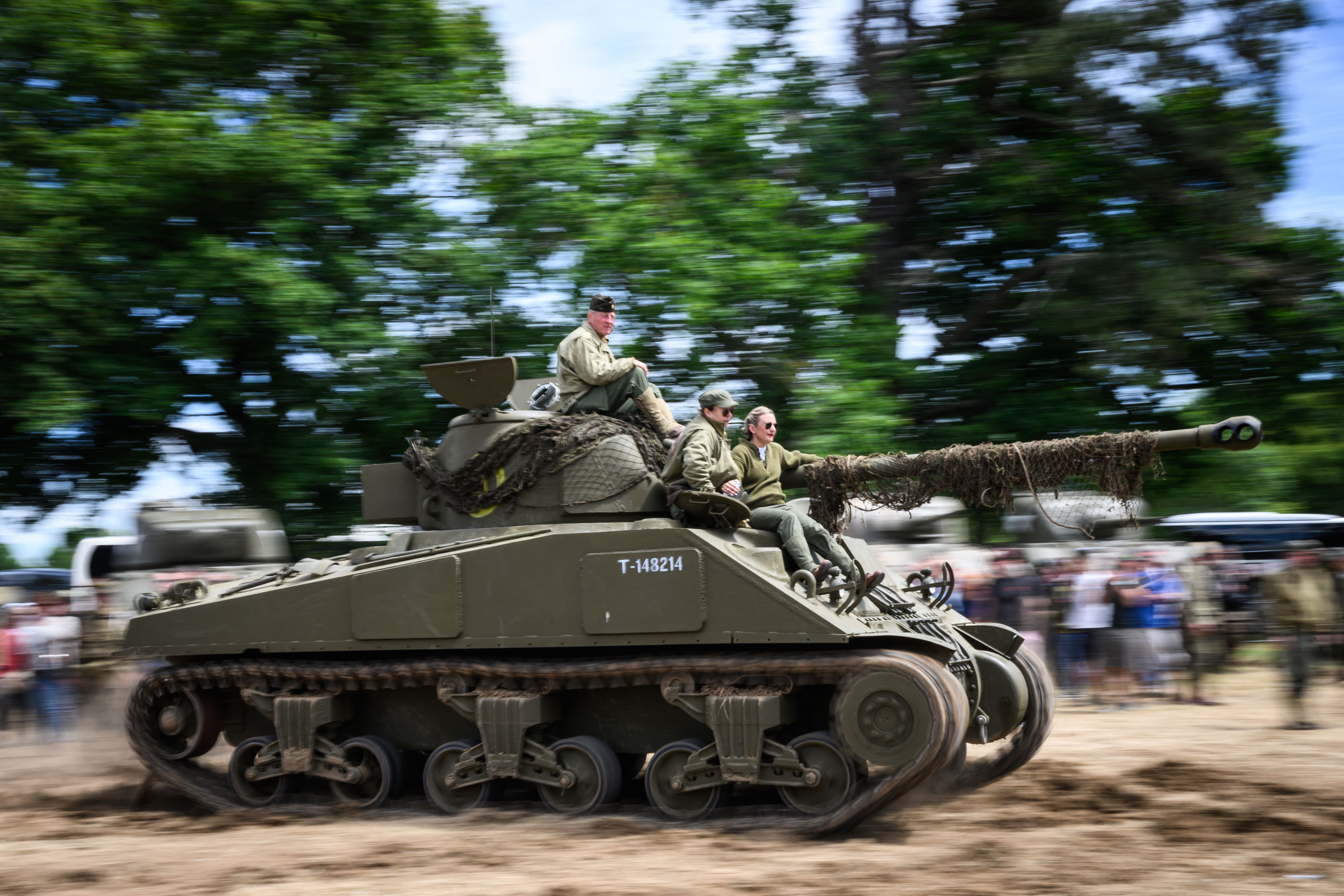 Enthusiasts wearing replica WWII military attire atop a Sherman tank in Sainte-Mere-Eglise, France, on June 4.