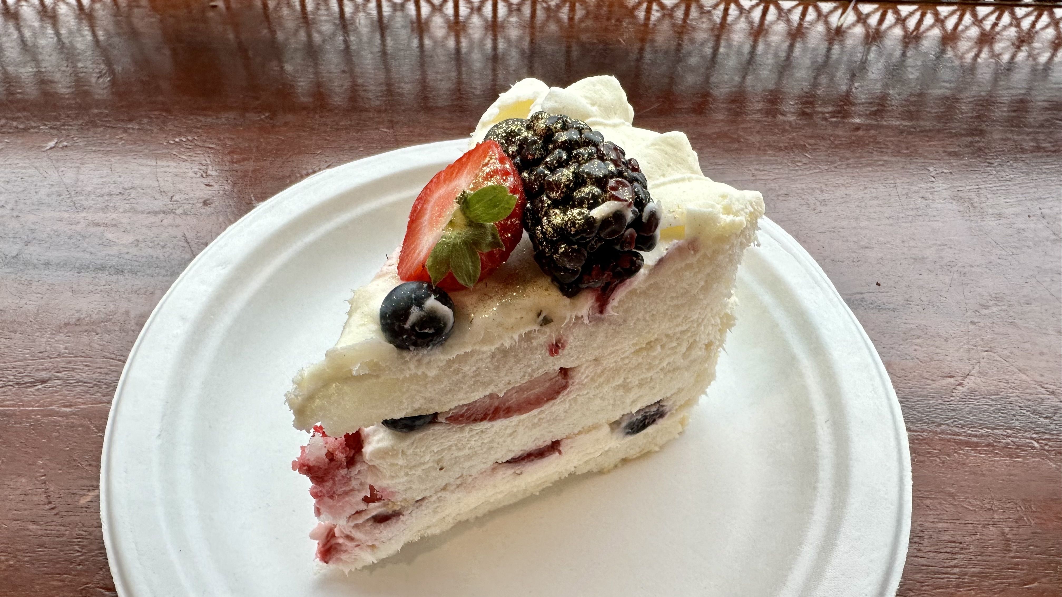 photo of a slice of berry Chantilly cake on a white paper plate