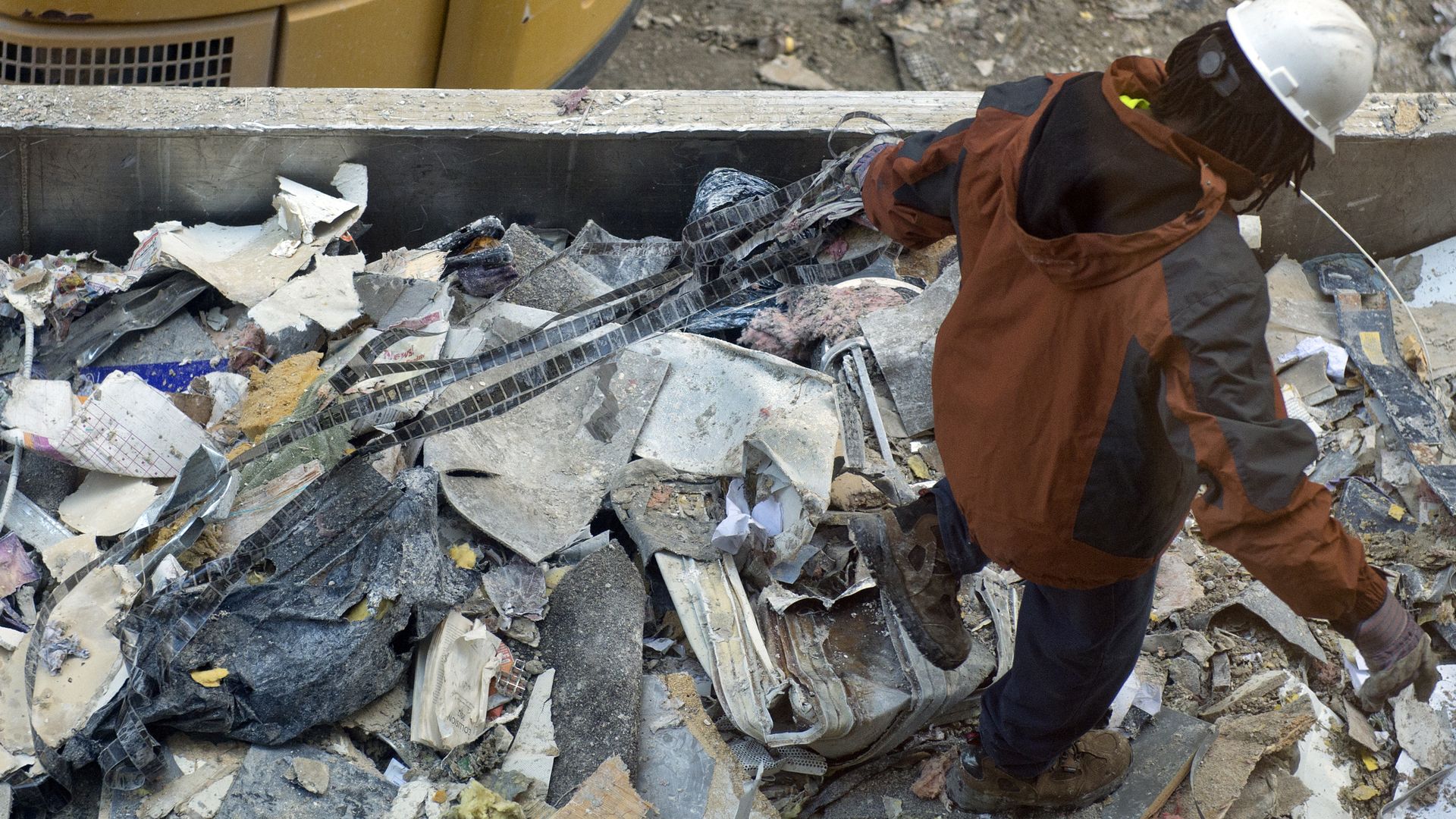 A worker sifts through trash in a dumpster in Washington