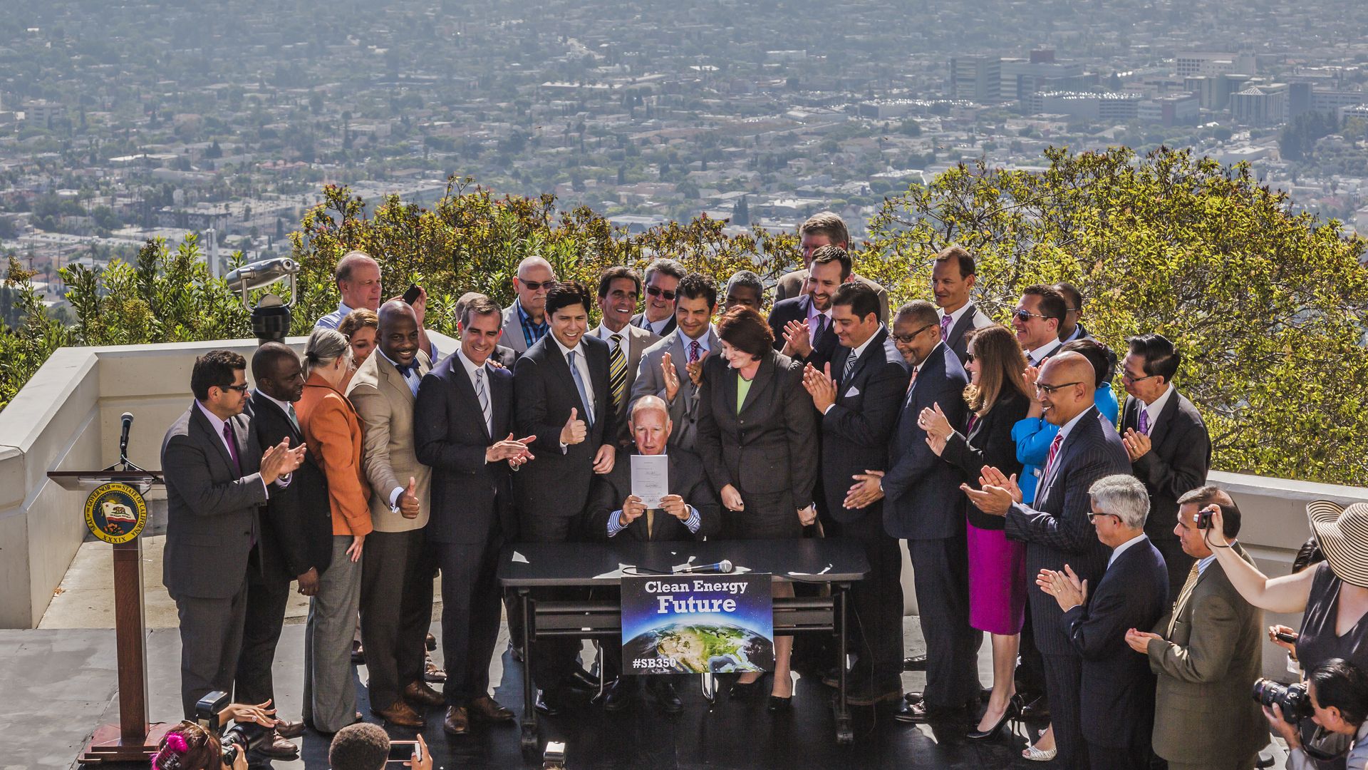 California governor Jerry Brown signs a bill into law with LA skyline behind him