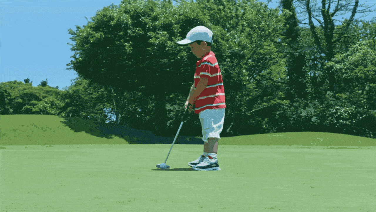 Image of a 4-year-old putting a golf ball