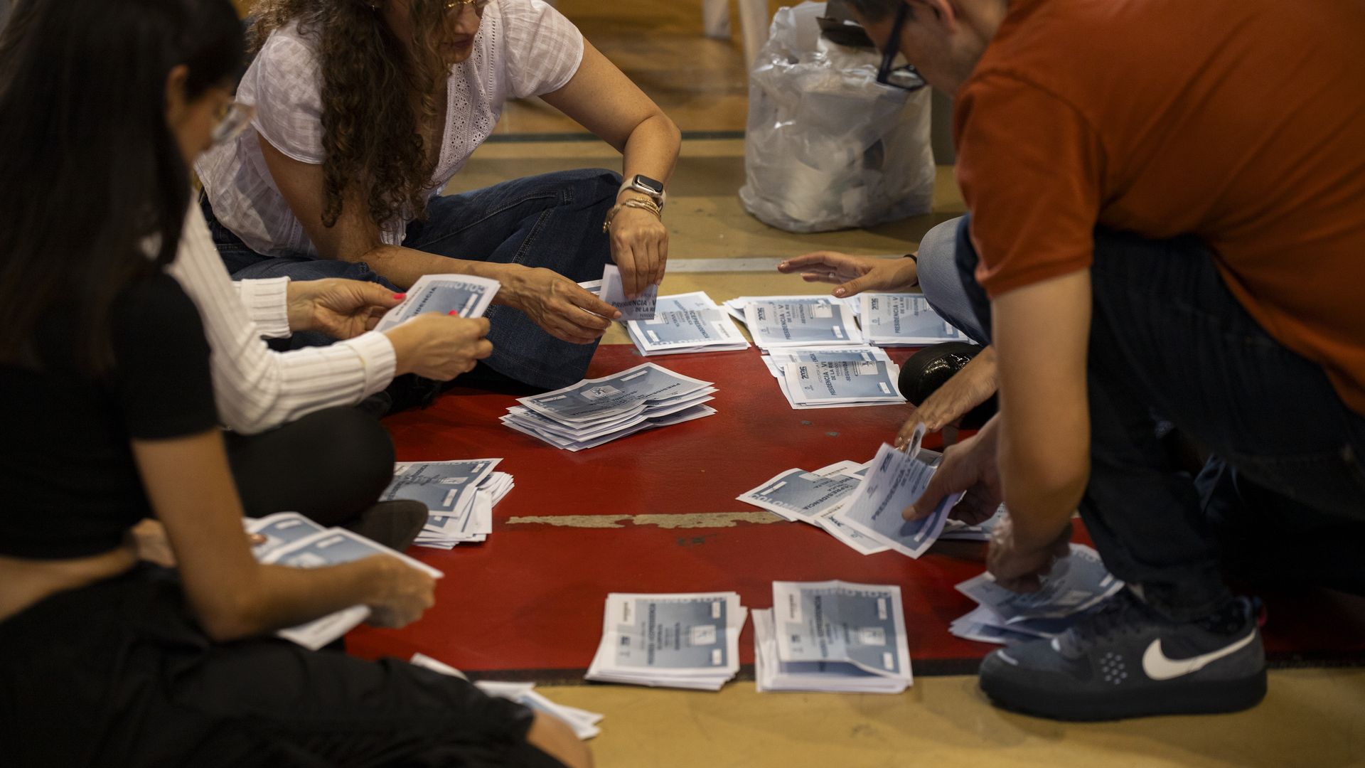 Colombian election officials count ballots on the floor at a polling station after voting closed during the second round of Colombia's presidential election