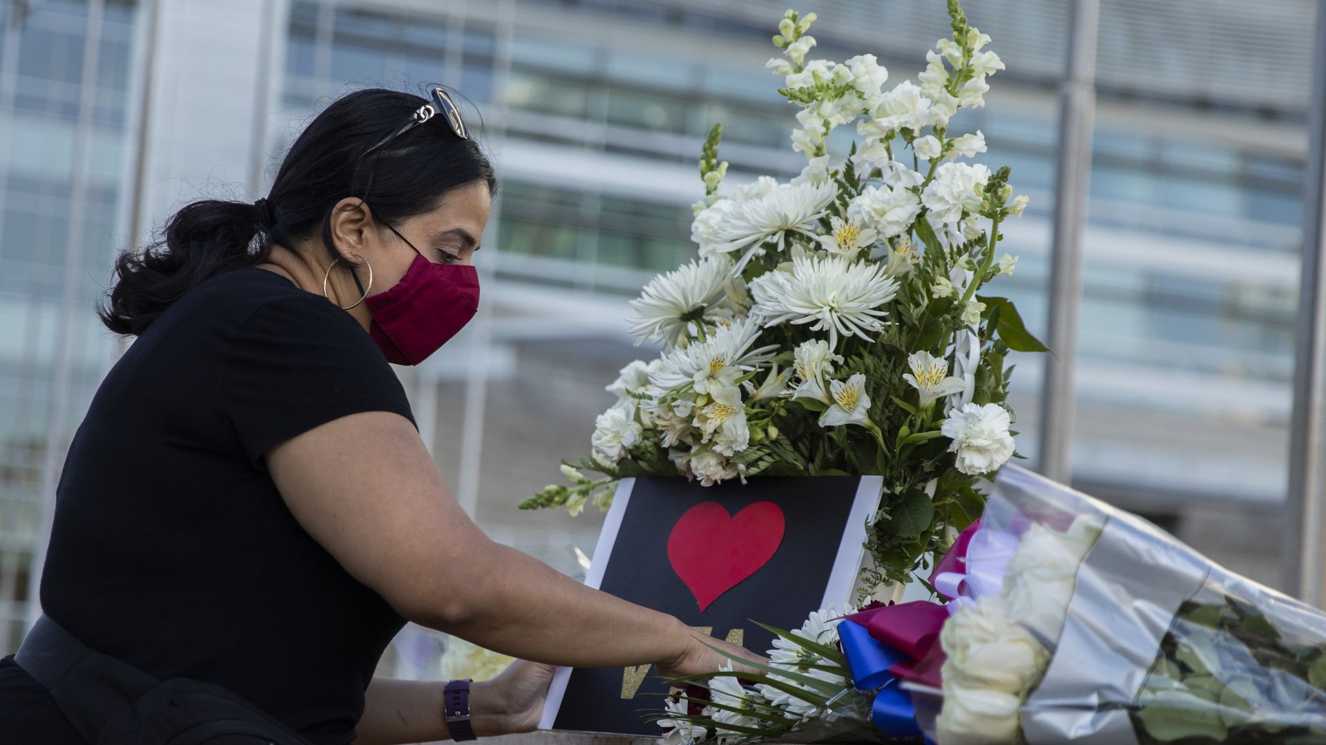 Jaspreet Kaur posts a sign at a vigil at City Hall, Wednesday, May 26, 2021, in San Jose, Calif.