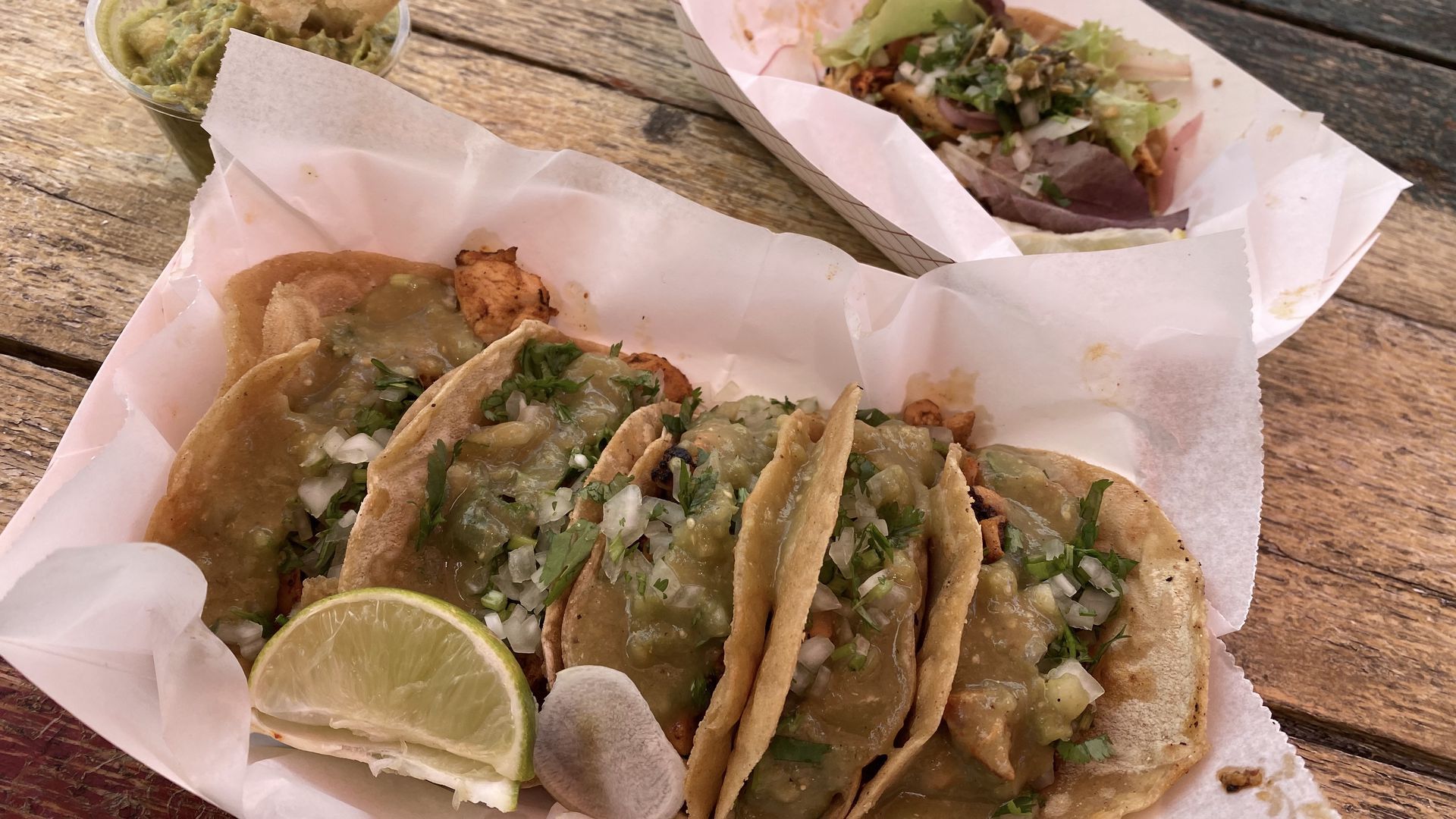A platter of tacos covered in salsa