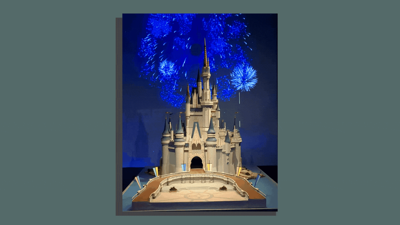 A model of Cinderella Castle with fireworks exploding behind it.  