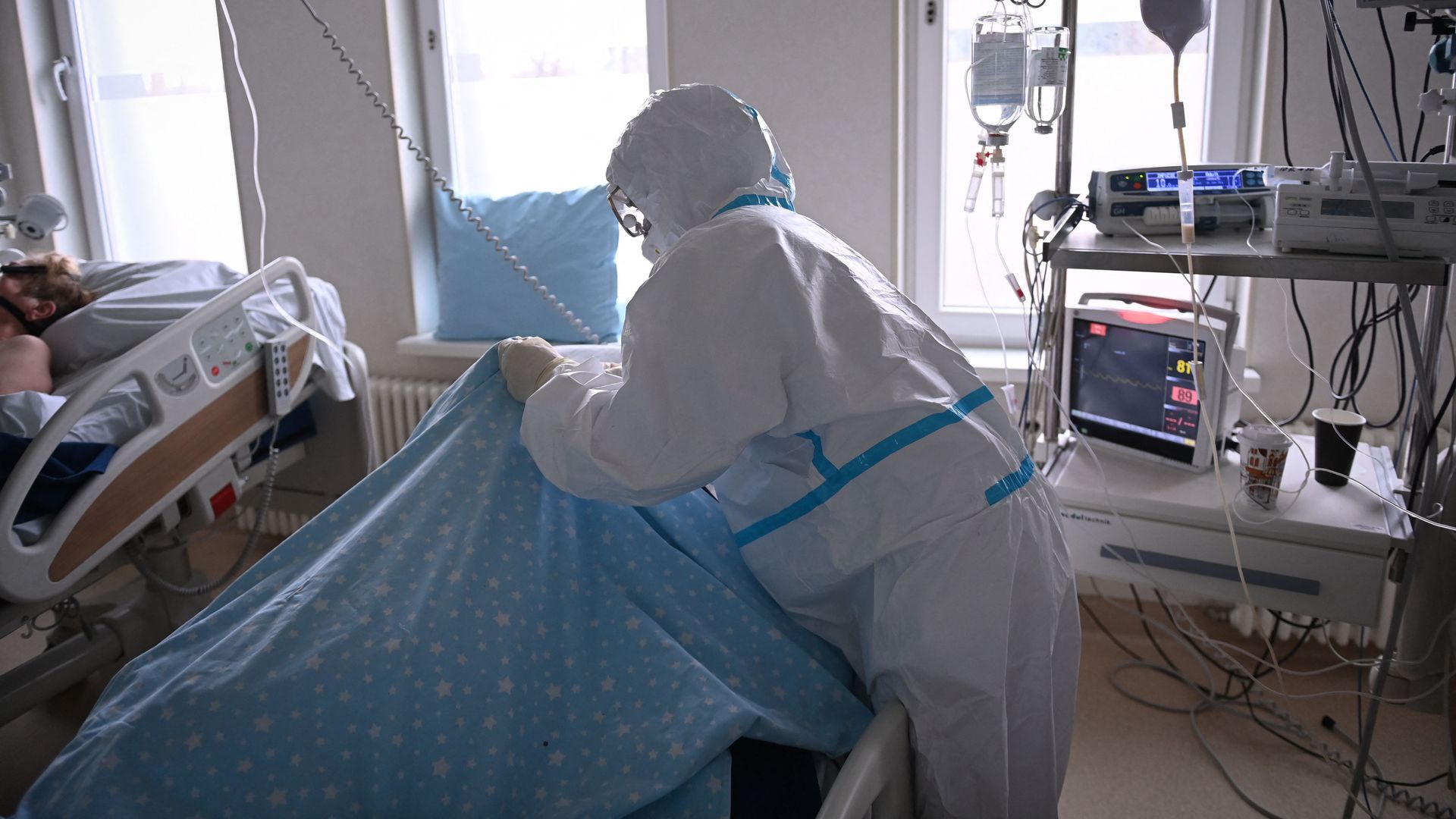 Picture of a medical worker wearing PPE while treating a COVID patient