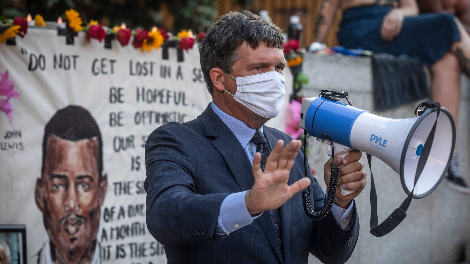State Rep. Mike Stewart holding a megaphone while wearing a mask.